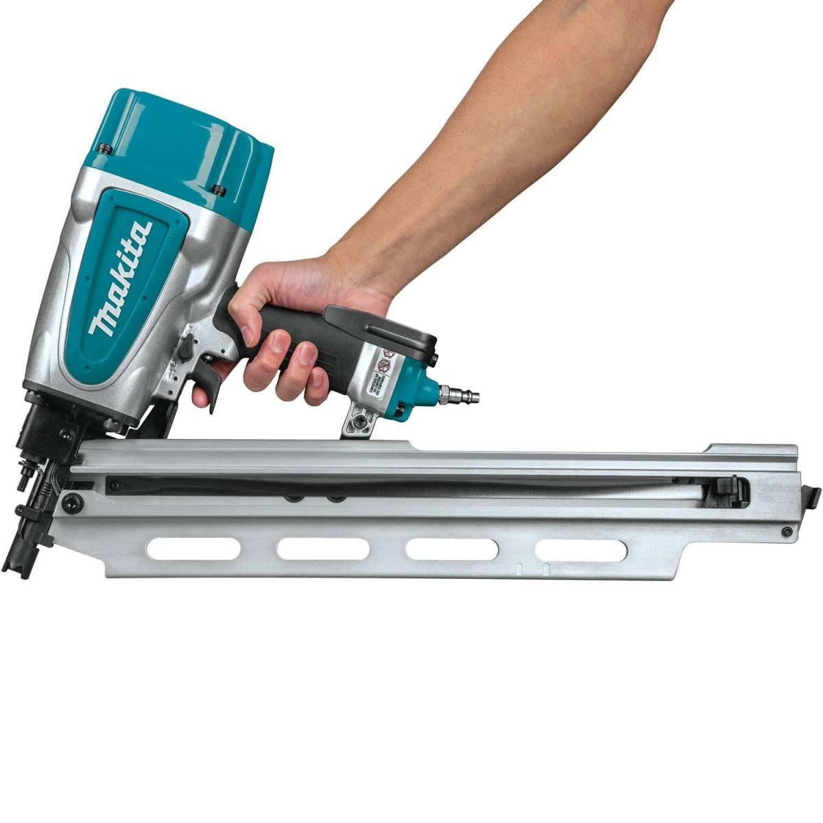 Eine Person hält einen Makita-Nagler. Die Pistole ist silber und blaugrün. Der Arm der Person ist sichtbar.