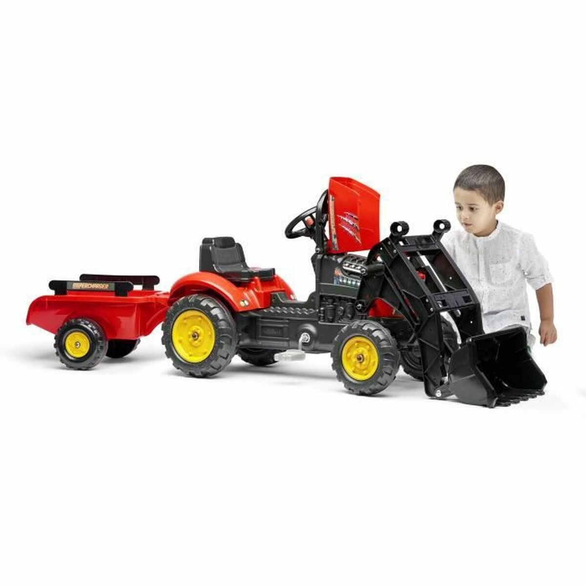 Ein Kind steht neben einem roten und schwarzen Spielzeugtraktor mit Anhänger. Der Traktor hat gelbe Räder. Das Kind trägt ein weißes Hemd.