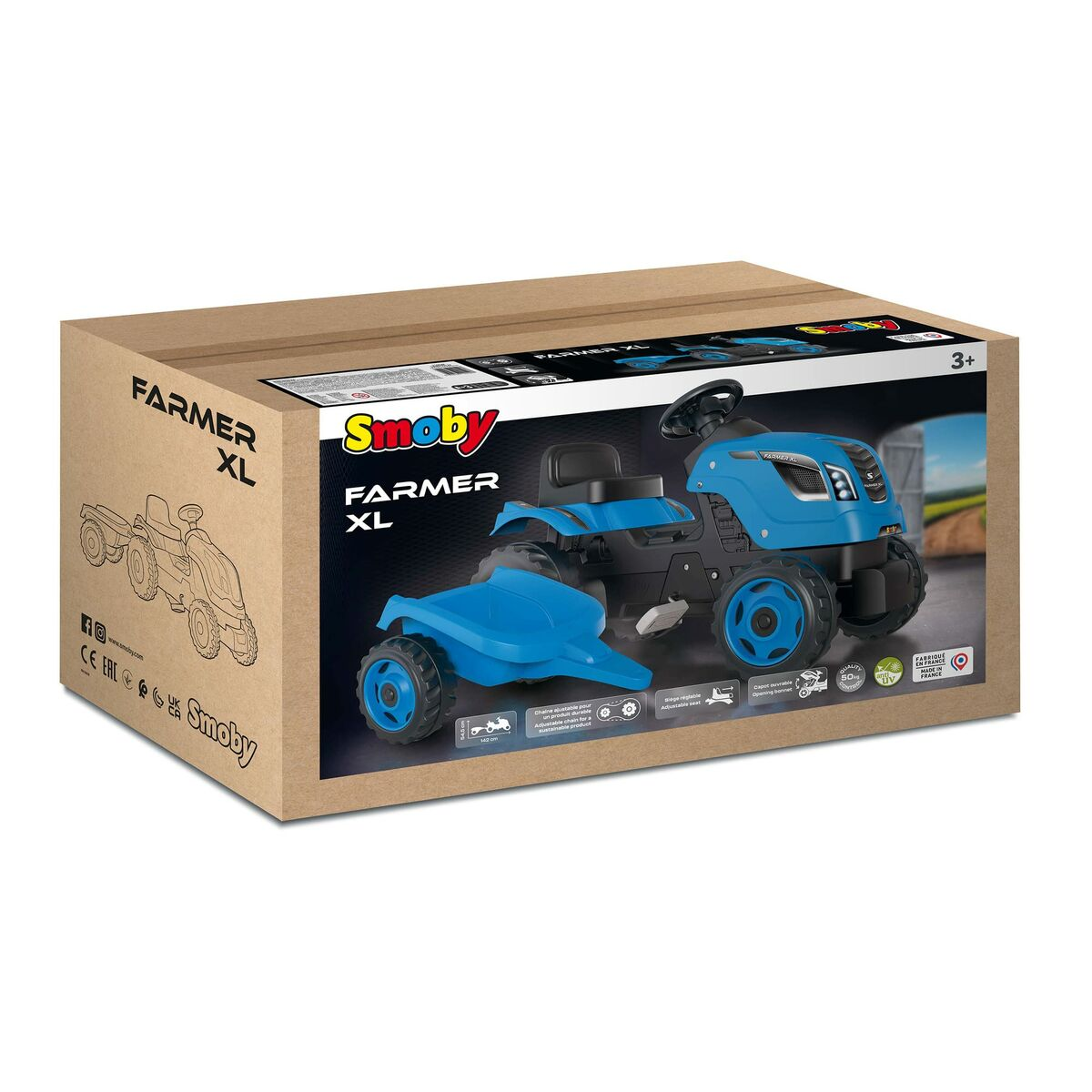 Ein blauer Smoby Farmer XL Traktor Spielzeug befindet sich in seinem Karton. Der Karton ist braun. Der Traktor hat schwarze und blaue Details.