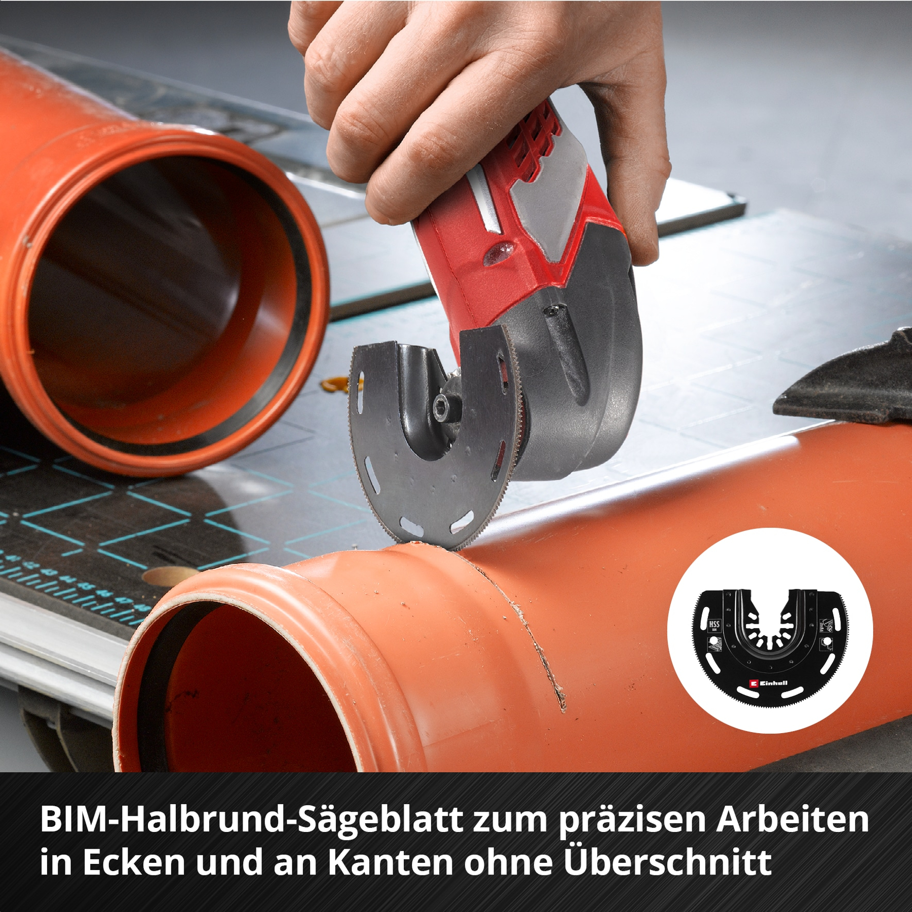 Eine Hand hält eine rot-schwarze Säge, die ein orangefarbenes Rohr schneidet. Eine Kreiss ägeblatt wird verwendet.