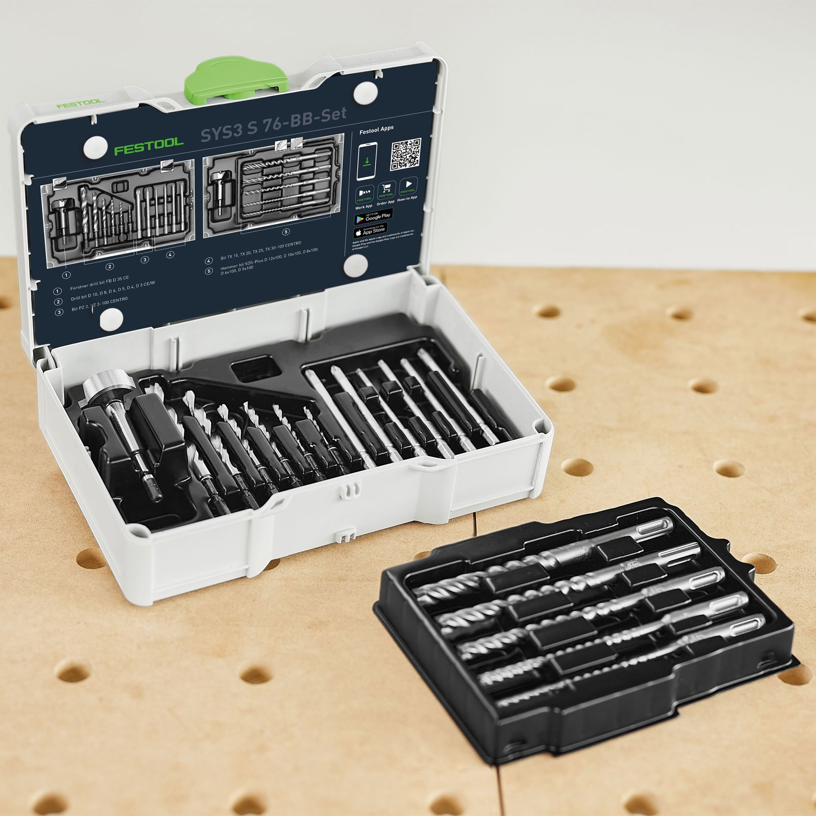 Ein weißes Festool-Werkzeugset ist geöffnet und zeigt verschiedene Bohrer. Eine separate schwarze Schale enthält weitere Bohrer. Der Hintergrund ist Holz.