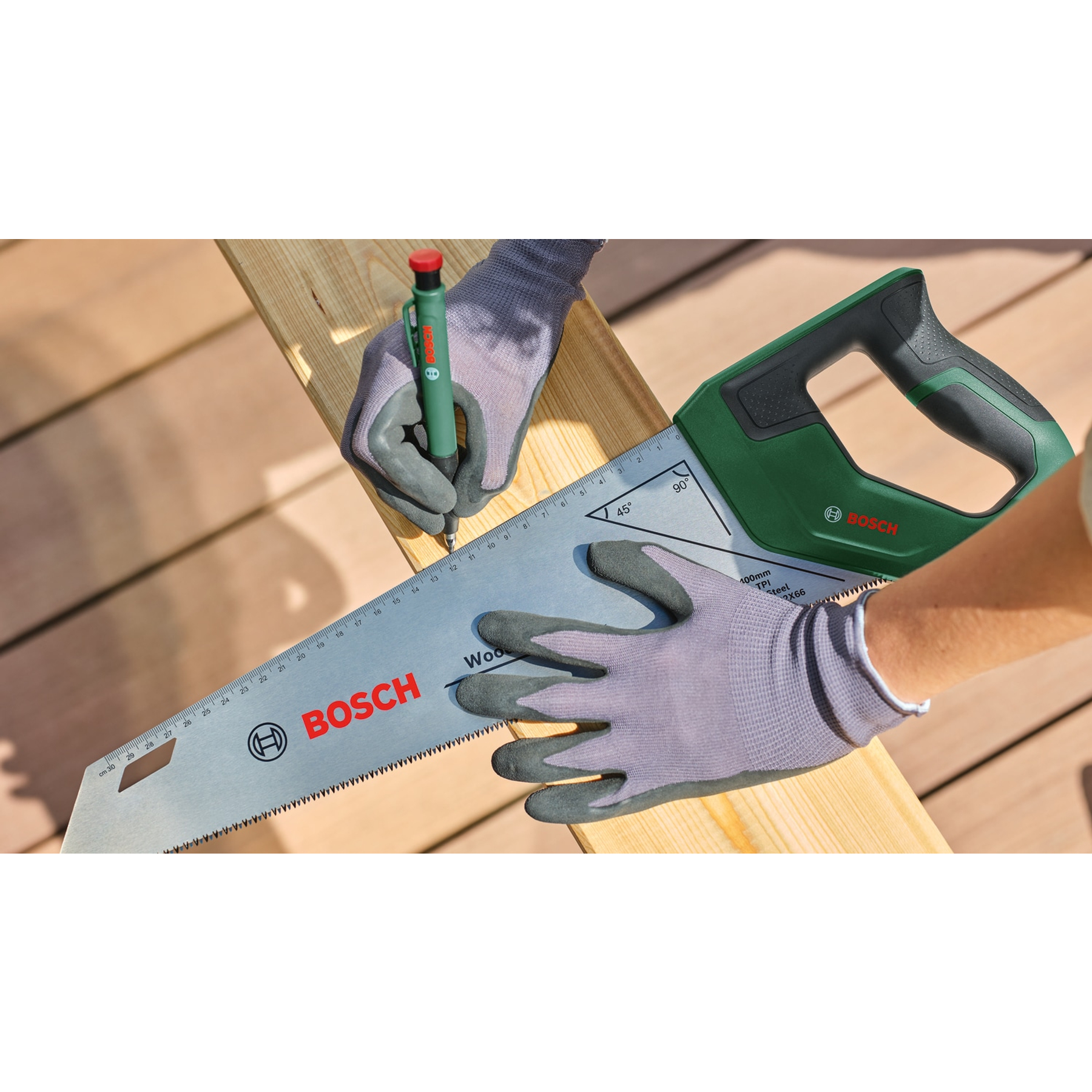 Hände mit Handschuhen verwenden eine Bosch-Säge, um Holz zu schneiden. Ein Stift wird zum Markieren verwendet.