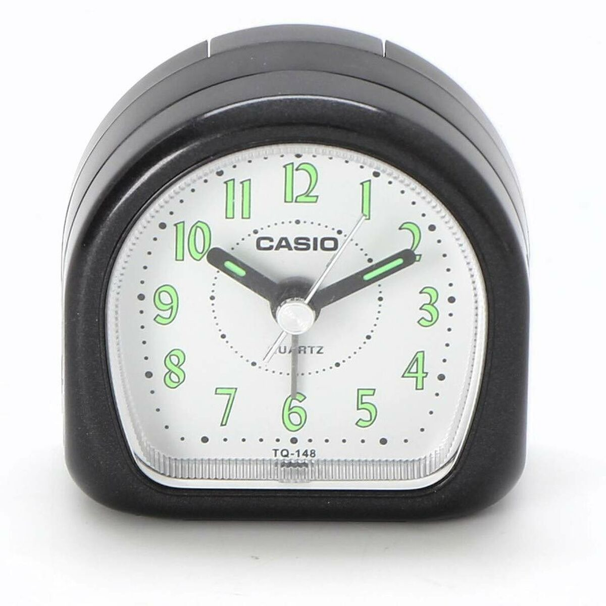 Schwarzer Casio-Wecker. Weißes Zifferblatt mit grünen Zahlen und Zeigern. Zeigt die Uhrzeit an. Quarz. Modell TQ-148.