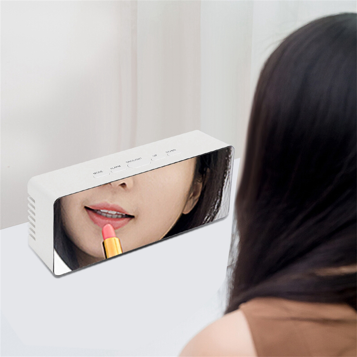 Eine Frau, die sich Lippenstift aufträgt, ist in einem spiegelartigen Wecker zu sehen. Das Gesicht der Frau wird reflektiert.