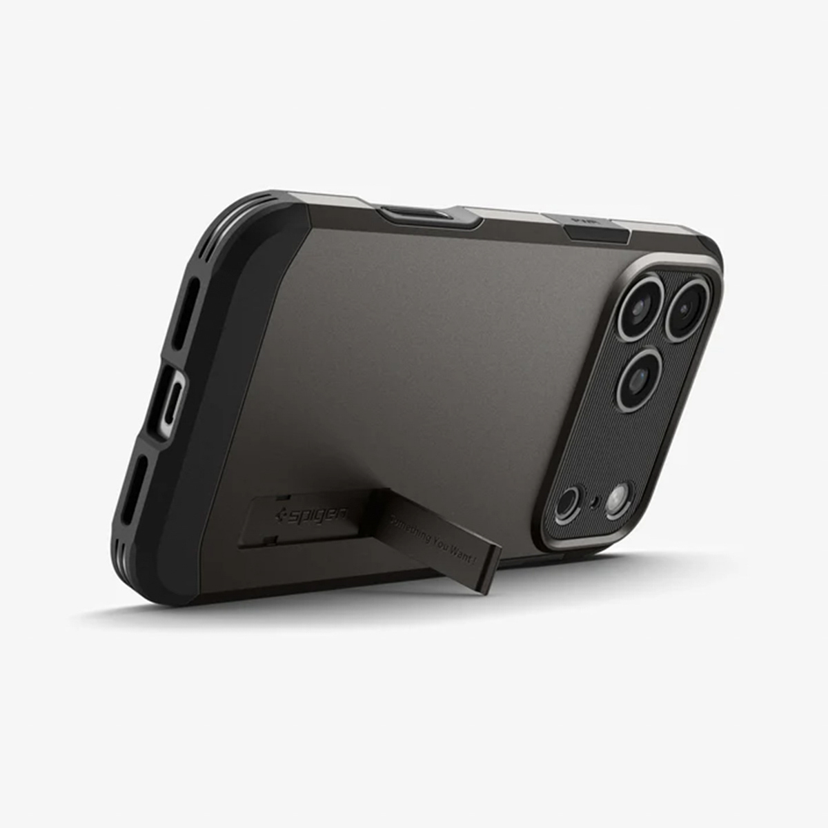 Un étui de téléphone gris foncé avec un support. L'étui a un cadre noir et une bosse de caméra. Le logo Spigen est visible.