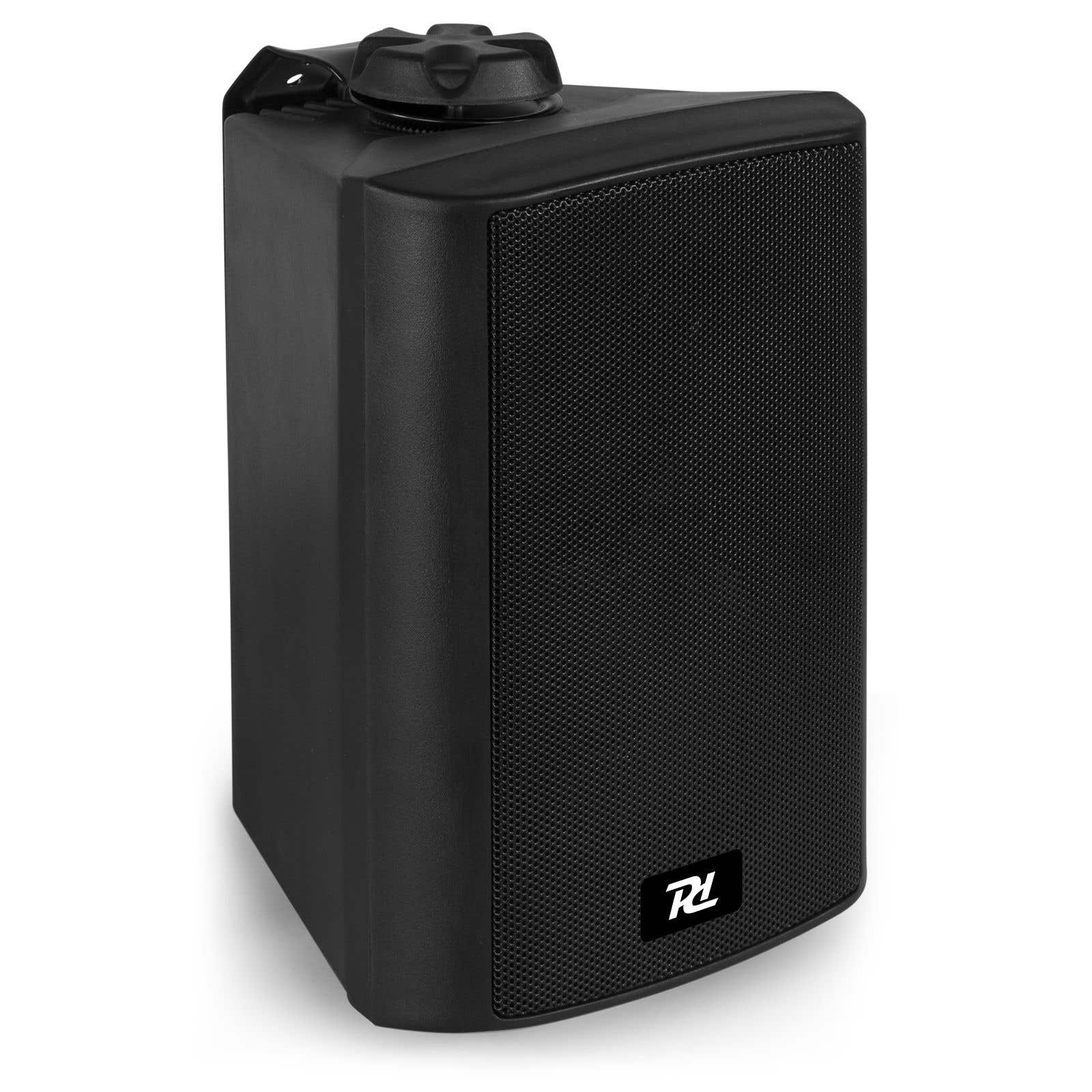 Un altavoz negro con una malla frontal, un asa y un logotipo. Está sobre un fondo blanco.