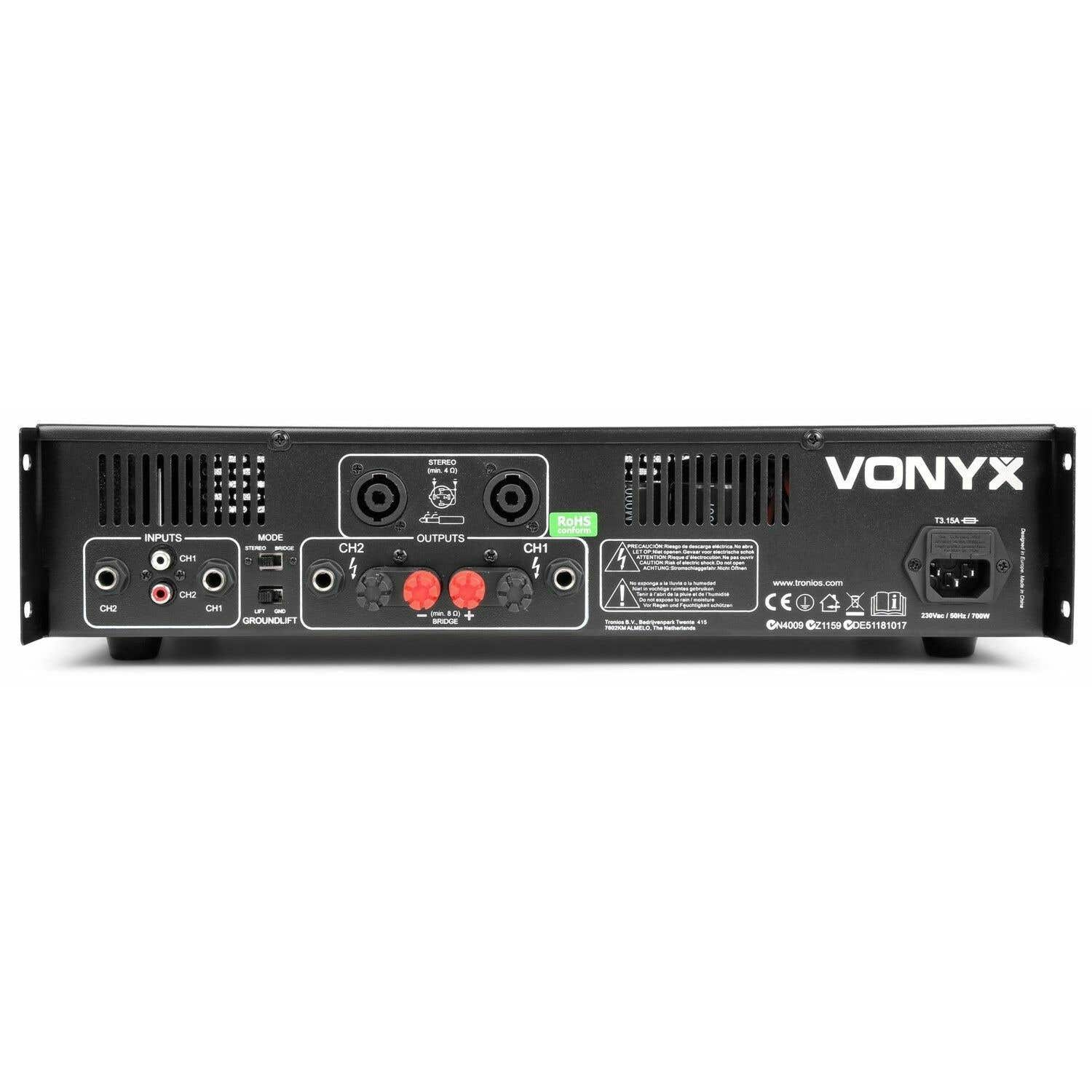 Amplificador Vonyx negro con puertos de entrada/salida, controles de modo y entrada de alimentación. Cuenta con varios conectores y etiquetas de advertencia.