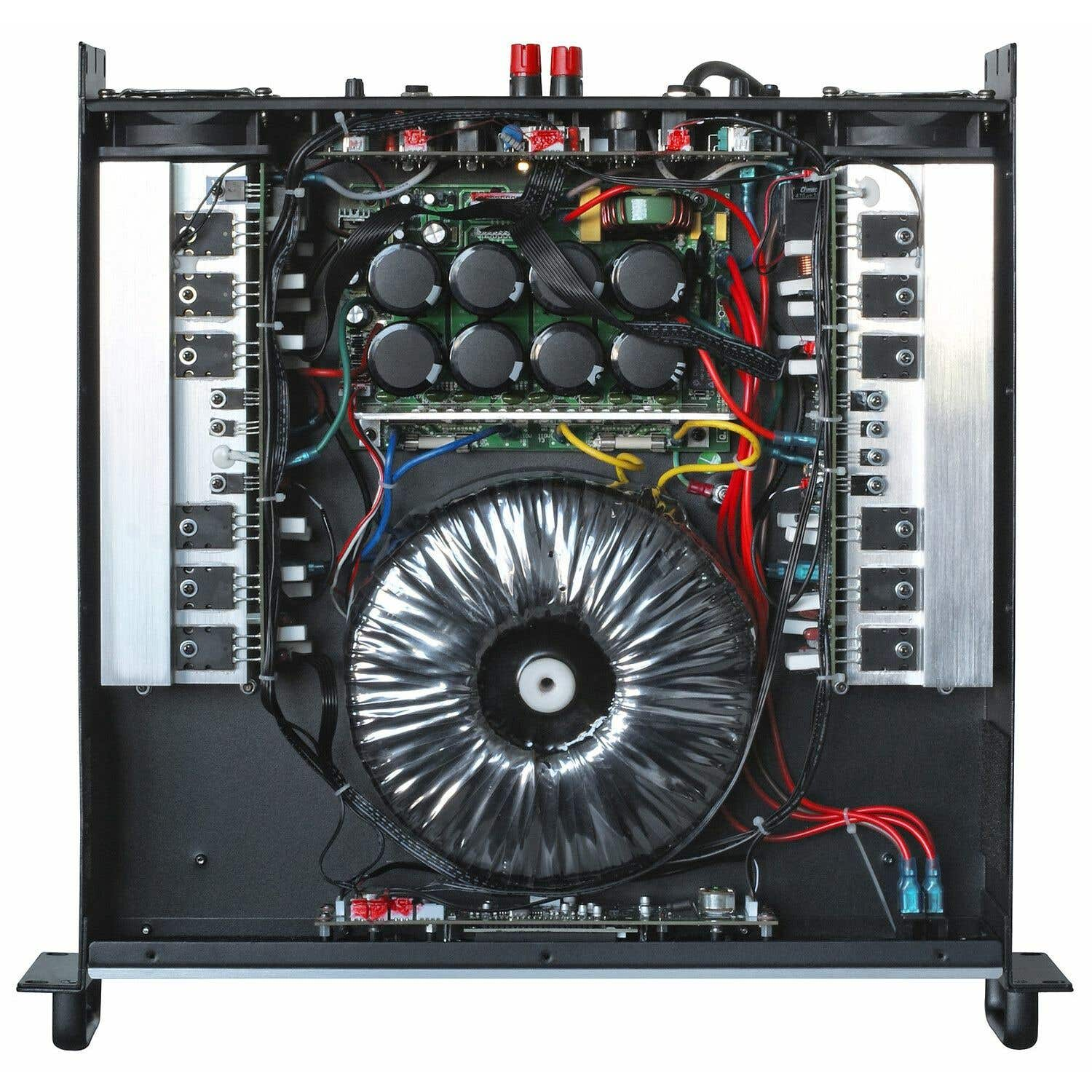 Interior de un amplificador. Chasis negro con placas de circuito, capacitores, cables y un transformador toroidal grande. Cables rojos y negros visibles.
