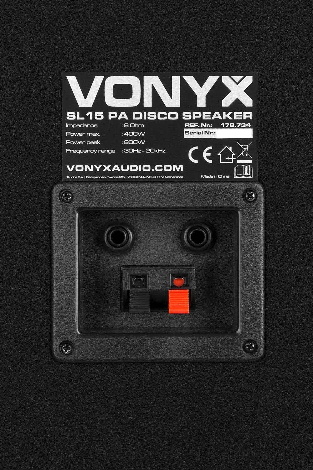 Primer plano de un panel de altavoz negro con texto blanco: 'VONYX', especificaciones y conector. Abajo: negro con conectores rojos.