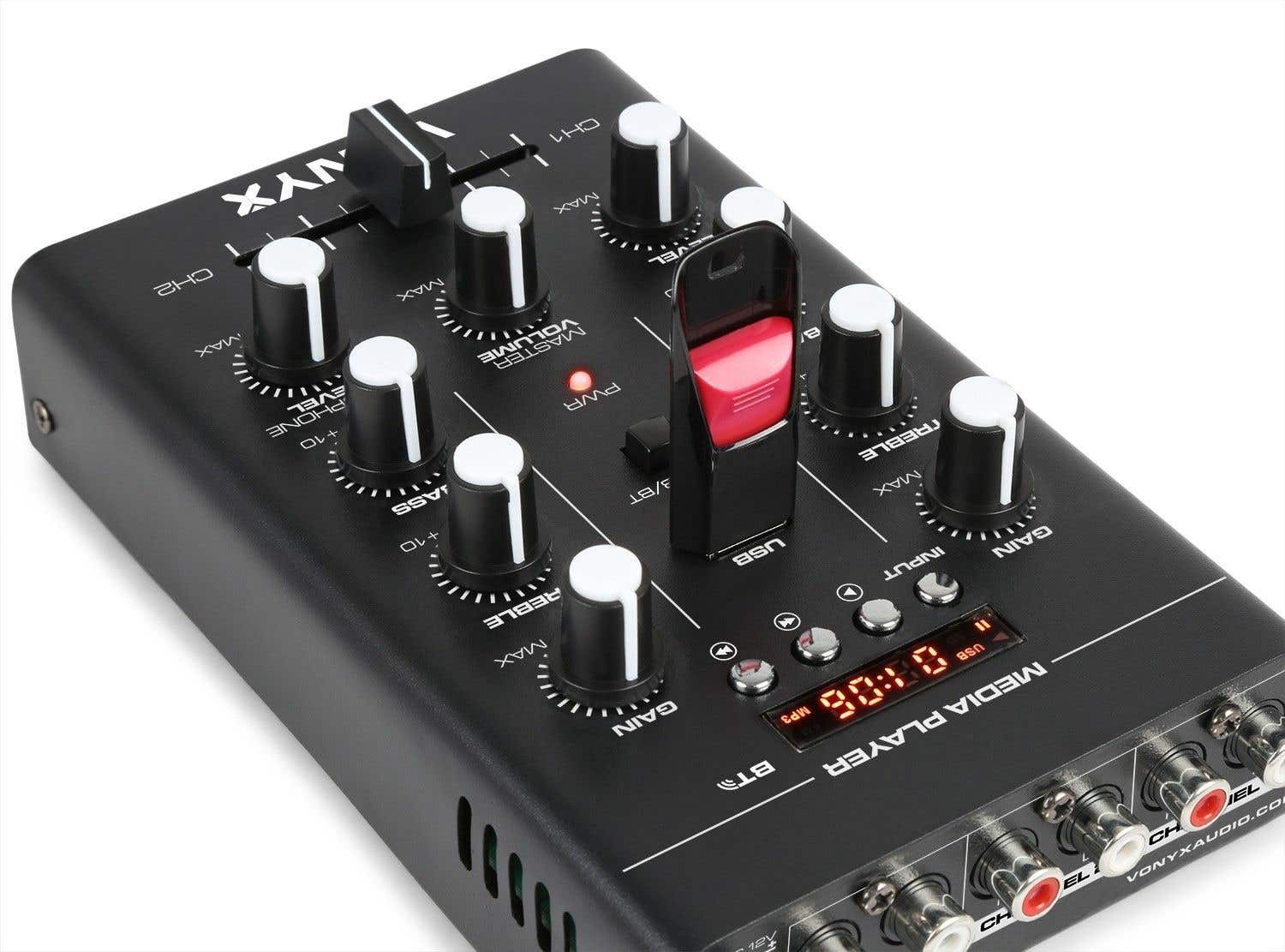 Un mezclador de audio negro con perillas y un puerto USB que sostiene una unidad USB roja y negra, con una pantalla digital.