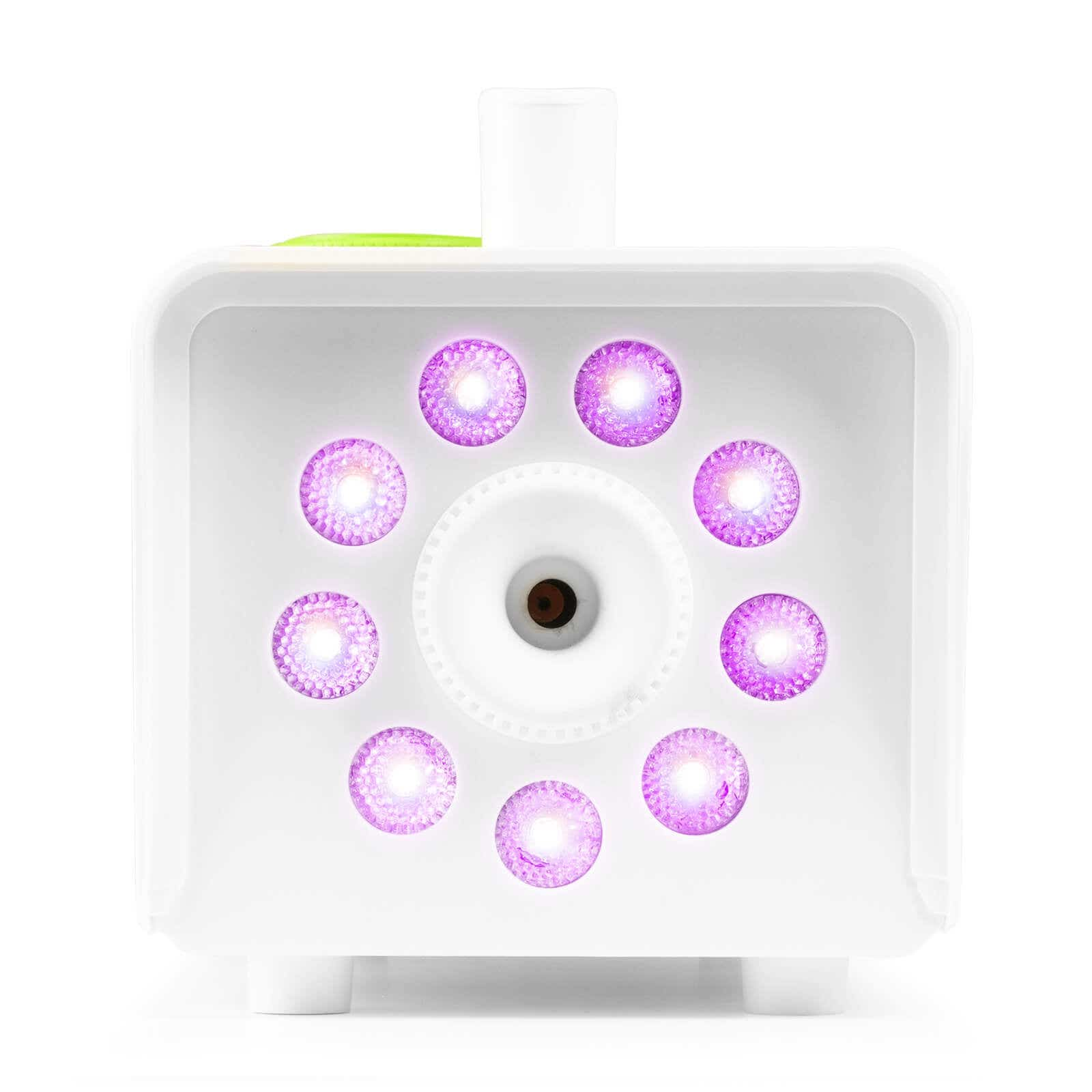 Dispositivo blanco con luces moradas. Tiene una lente central y un asa. Las luces están dispuestas en círculo.