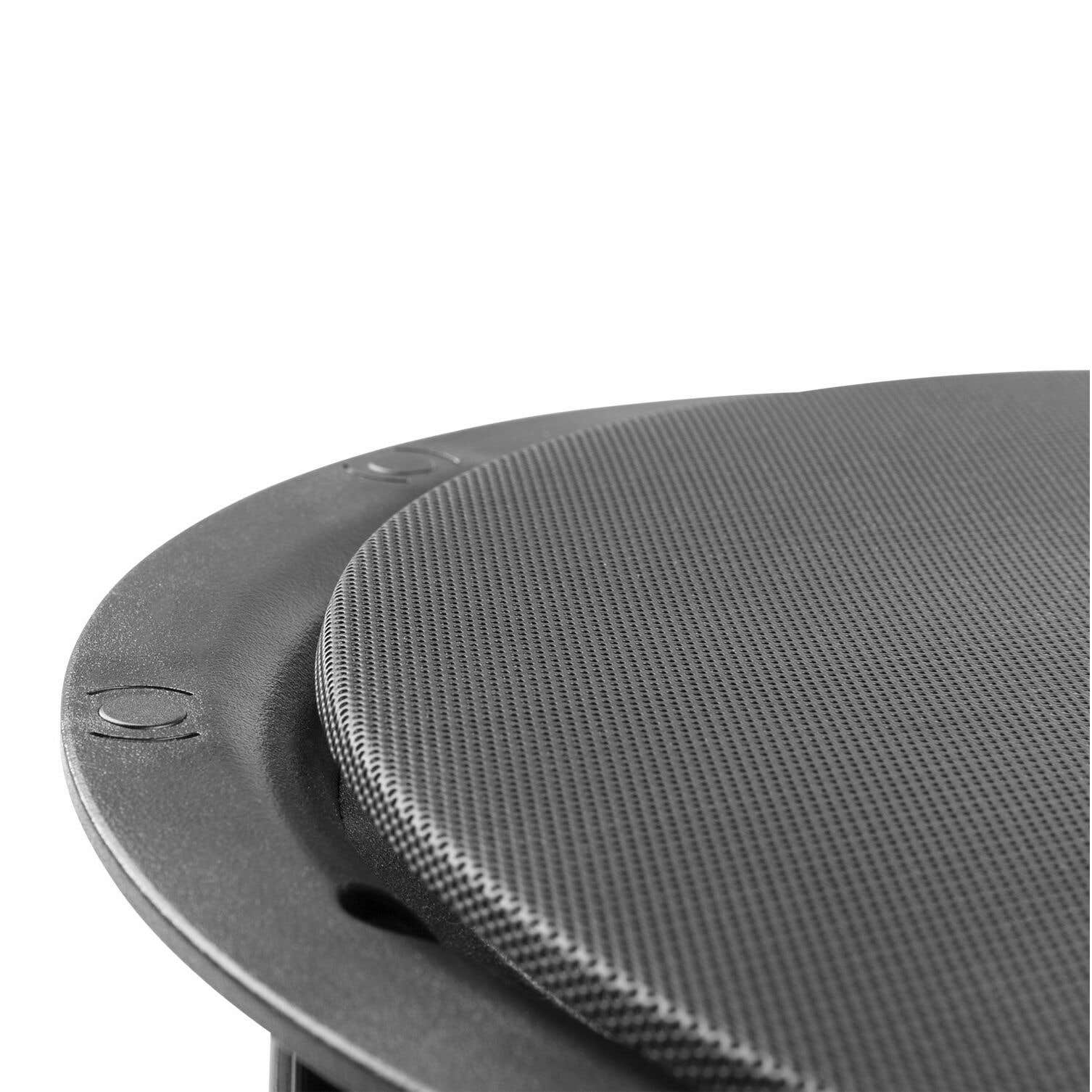 Primer plano de un componente de altavoz negro. Tiene una superficie texturizada y un marco circular oscuro. El fondo es blanco.