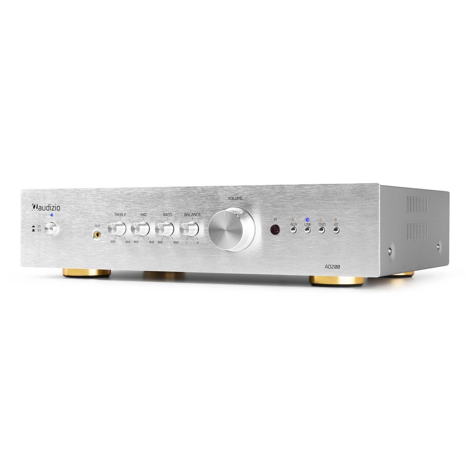 Amplificador de audio plateado con perillas y botones. La marca es 'Maudizio'. Pies dorados. Controles de agudos, graves y volumen son visibles.