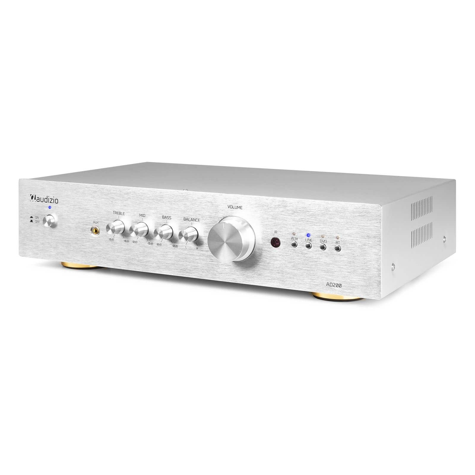 Amplificador de audio plateado con perillas para agudos, medios, bajos y balance. Tiene un mando de volumen y botones de selección.