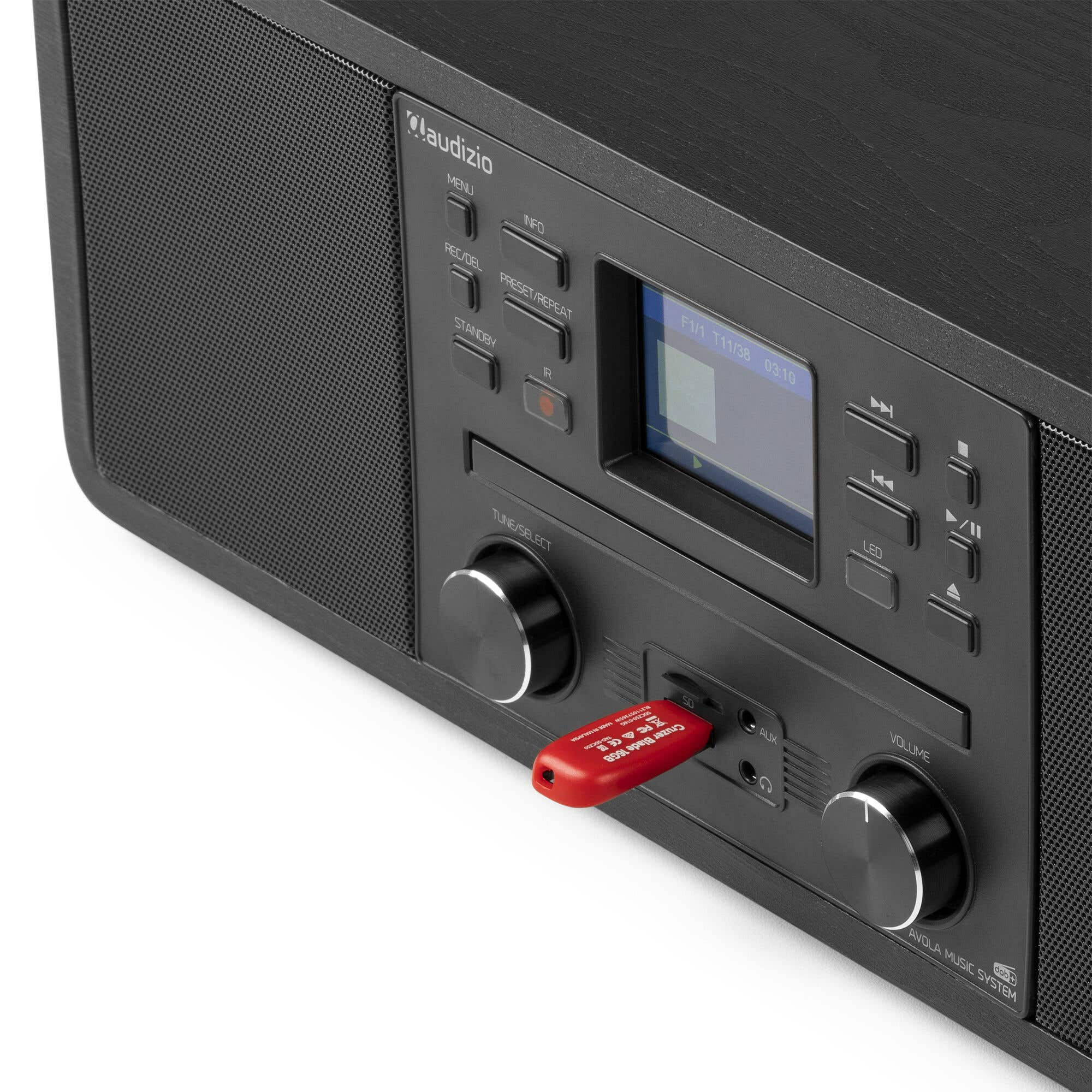 Schwarzes Audizio-Musiksystem mit rotem USB-Stick. Es hat Knöpfe, Regler und ein kleines Display.