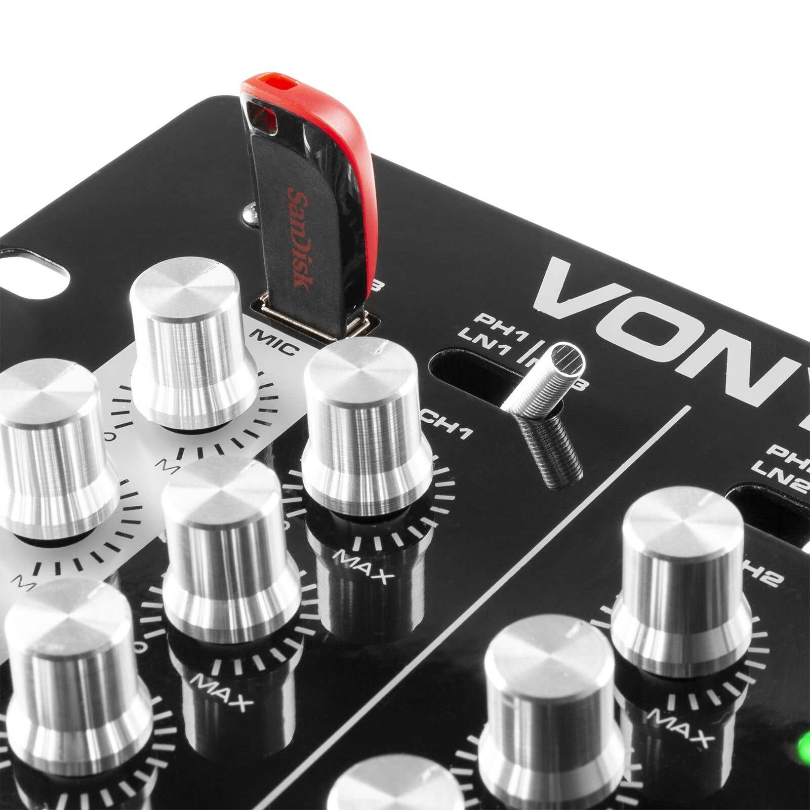 Un panel de control negro con perillas plateadas, una unidad USB roja y negra y marcas blancas. La palabra 'VON' es visible.