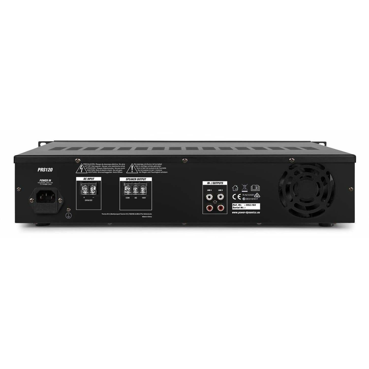 Amplificador de audio negro con múltiples puertos de entrada/salida y entrada de alimentación. El panel frontal tiene señales de advertencia y etiquetas.