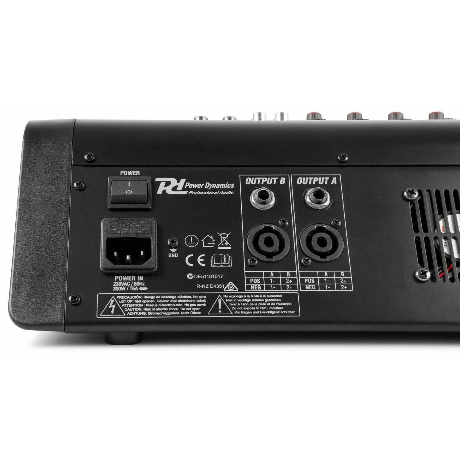 Panel trasero de mezclador de audio negro con entrada de alimentación, puertos de salida y etiquetas de advertencia.