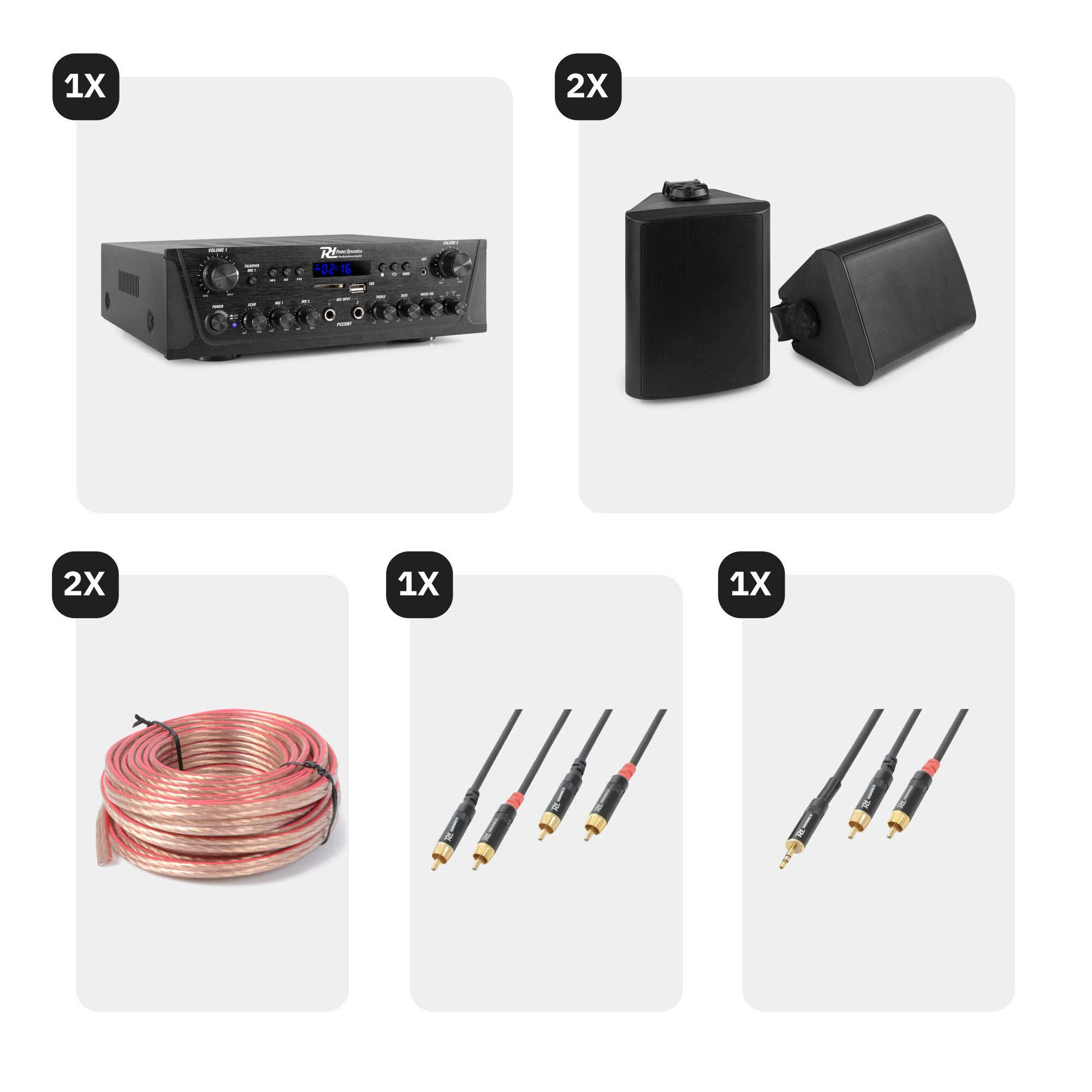 Un amplificador, dos altavoces, una bobina de cable de altavoz y cables de audio sobre un fondo blanco.