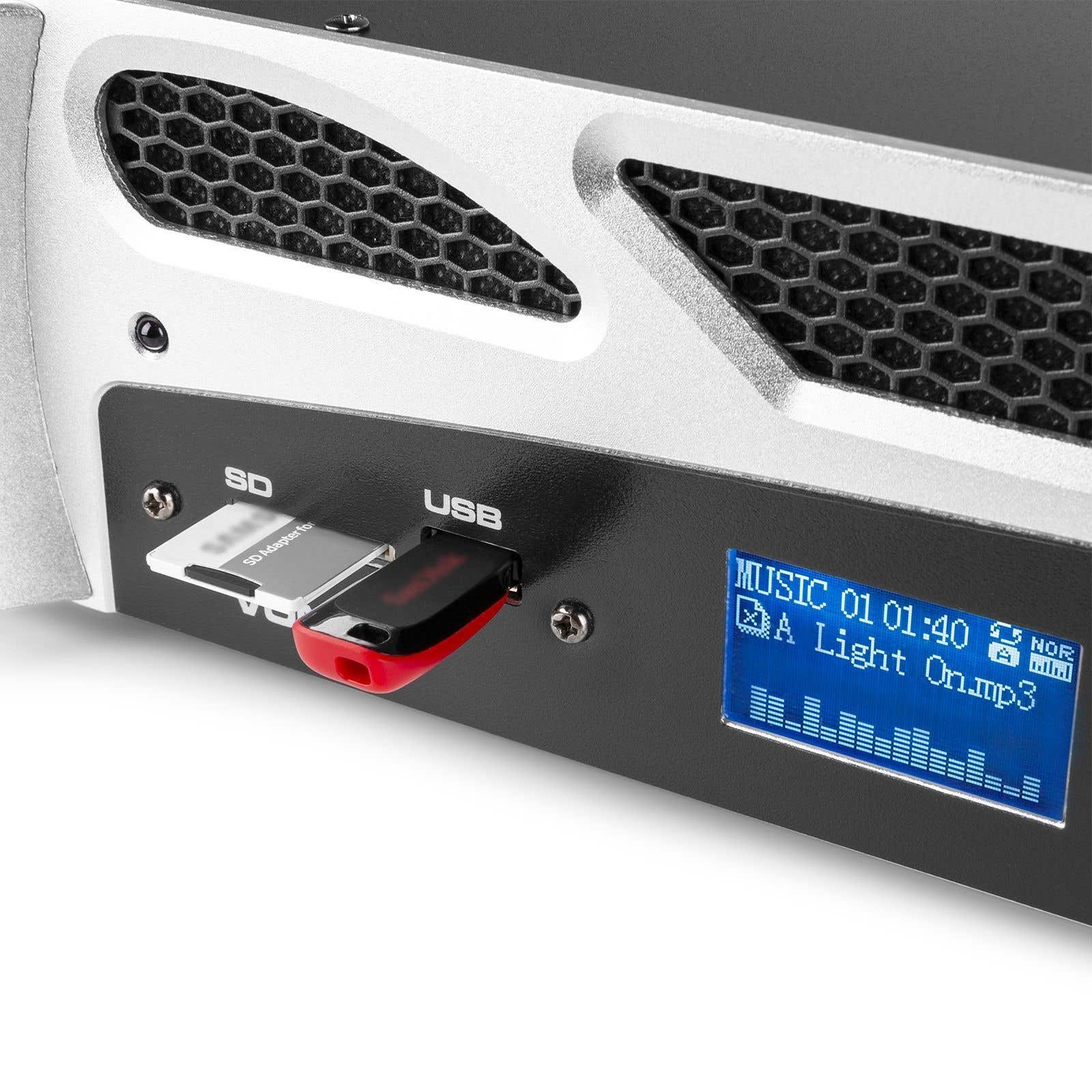 Primer plano de un dispositivo de audio. Tarjeta SD y unidad USB insertadas. Una pantalla muestra info de música.