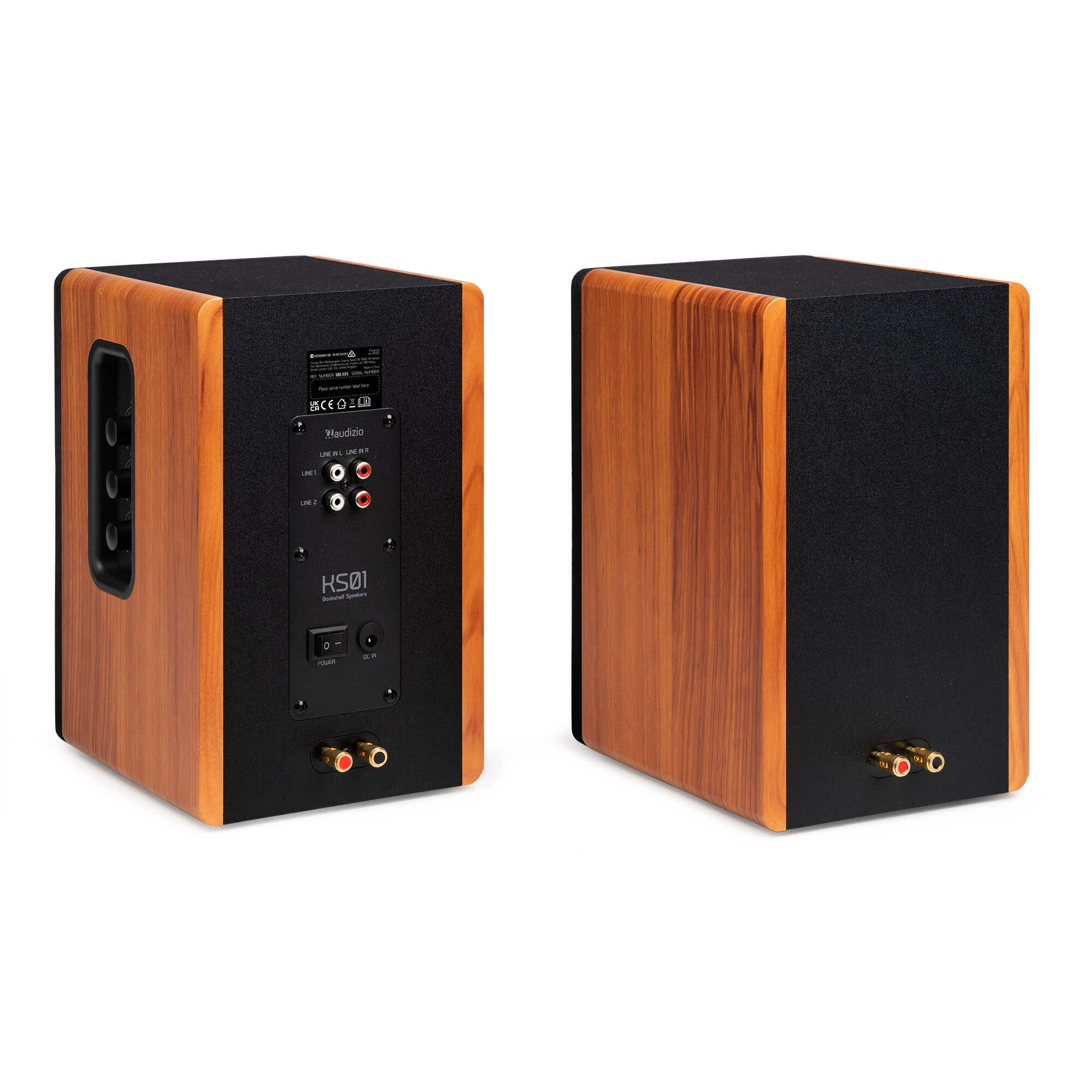 Dos altavoces de estantería de madera con tapas y respaldos negros. Uno muestra entradas y controles. El otro está en ángulo.