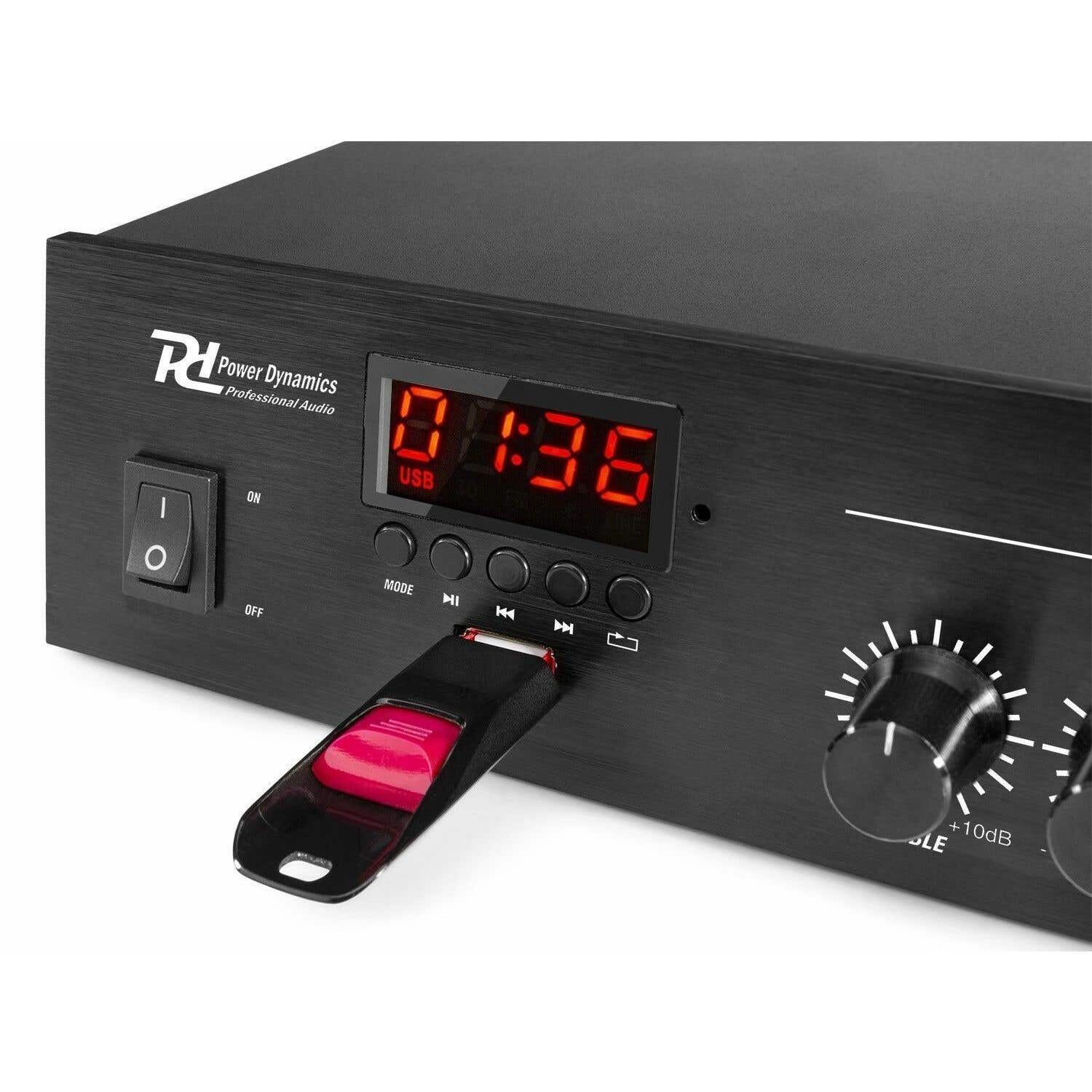 Dispositivo de audio negro con una unidad USB roja insertada. La pantalla muestra 01:36. Botón de encendido a la izquierda. Perillas a la derecha.