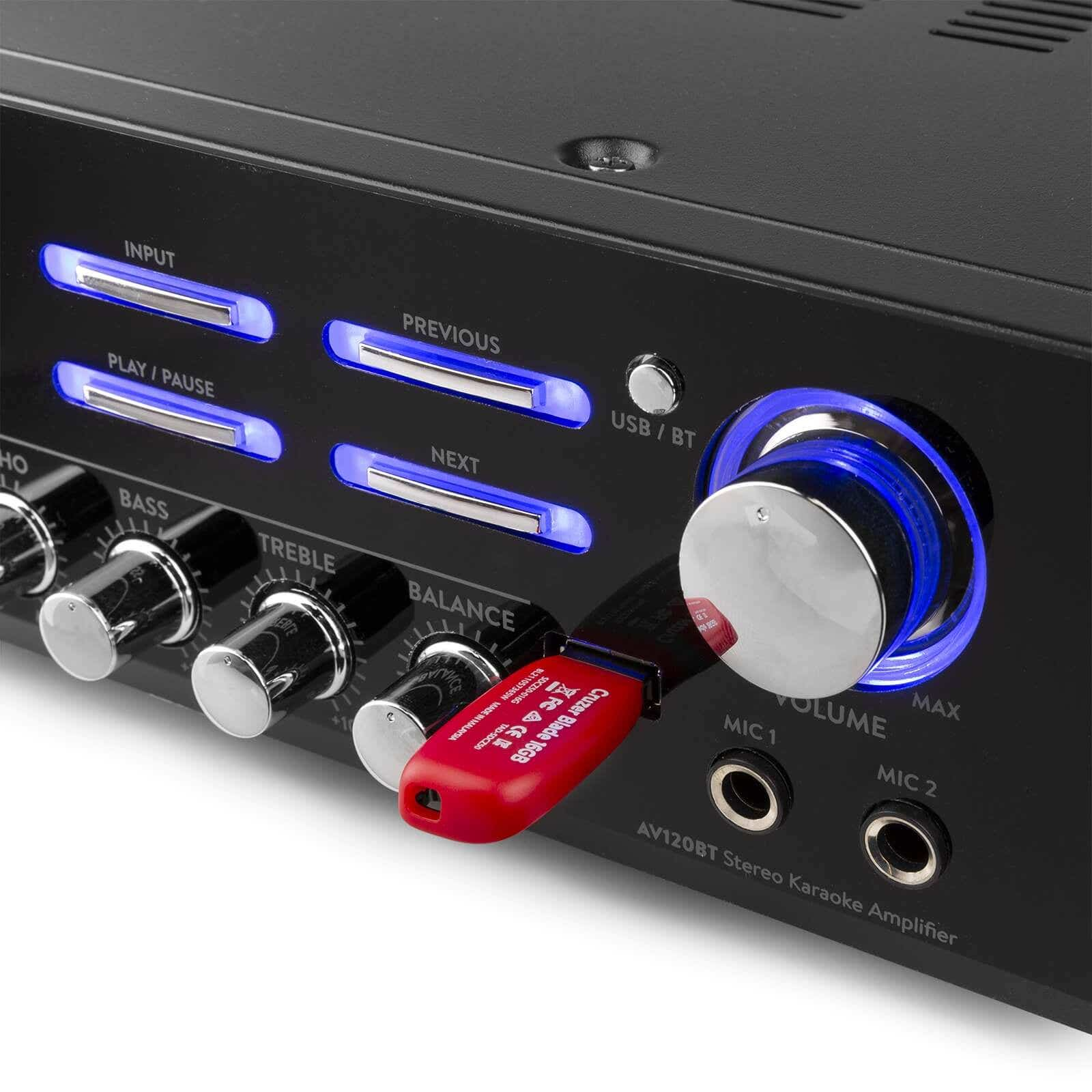 Amplificador estéreo negro con botones, perillas y una unidad USB roja insertada. Luces azules iluminan algunos botones.