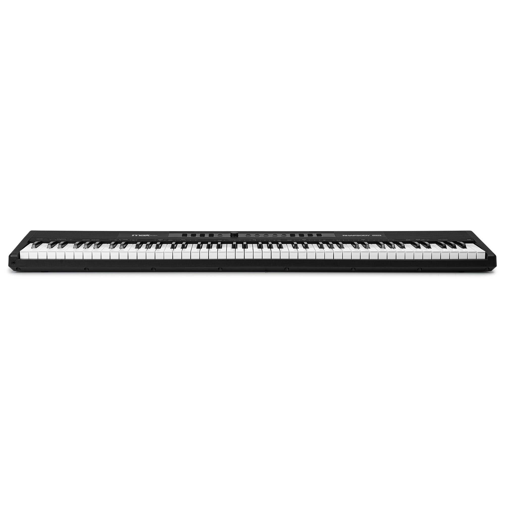 Un piano digital negro con teclas blancas y negras está centrado sobre un fondo blanco. El piano es un Rhapsody.
