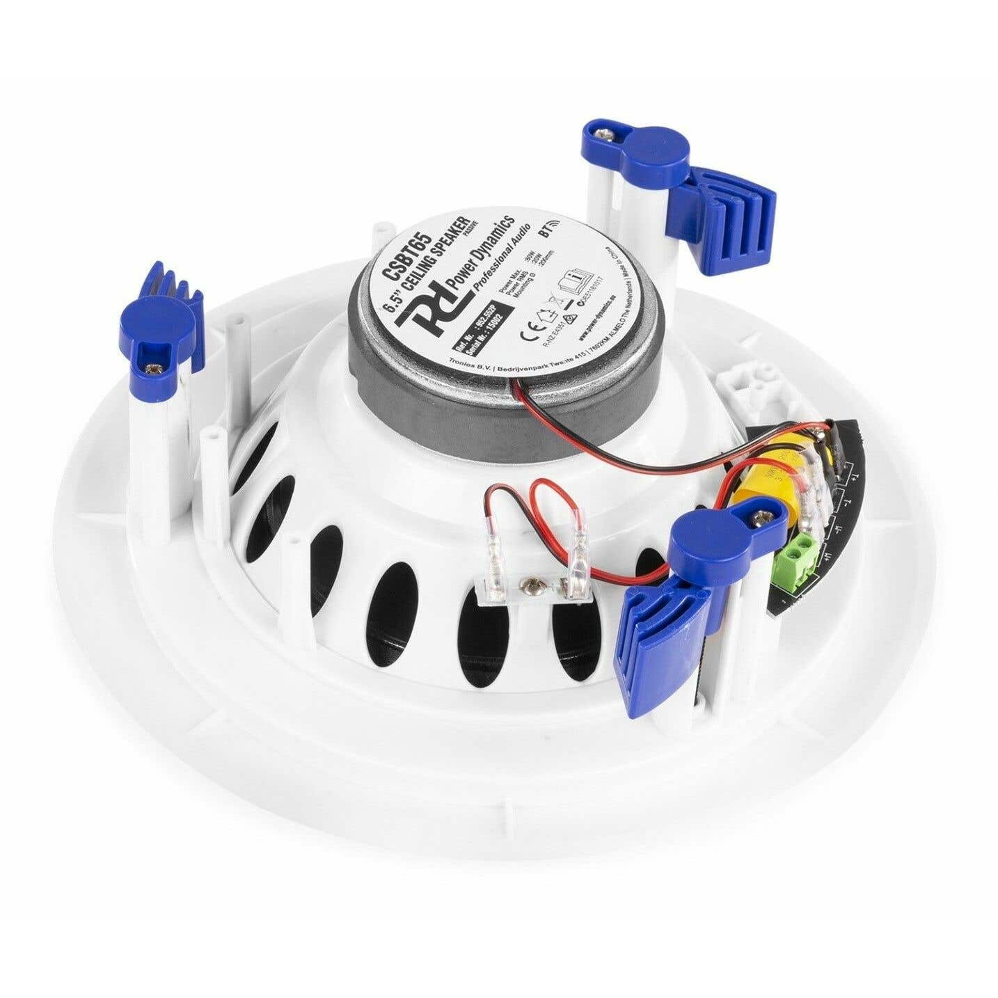 Un altavoz de techo blanco con un altavoz negro en el centro. Clips azules lo aseguran. Se ven cables y una placa de circuito.
