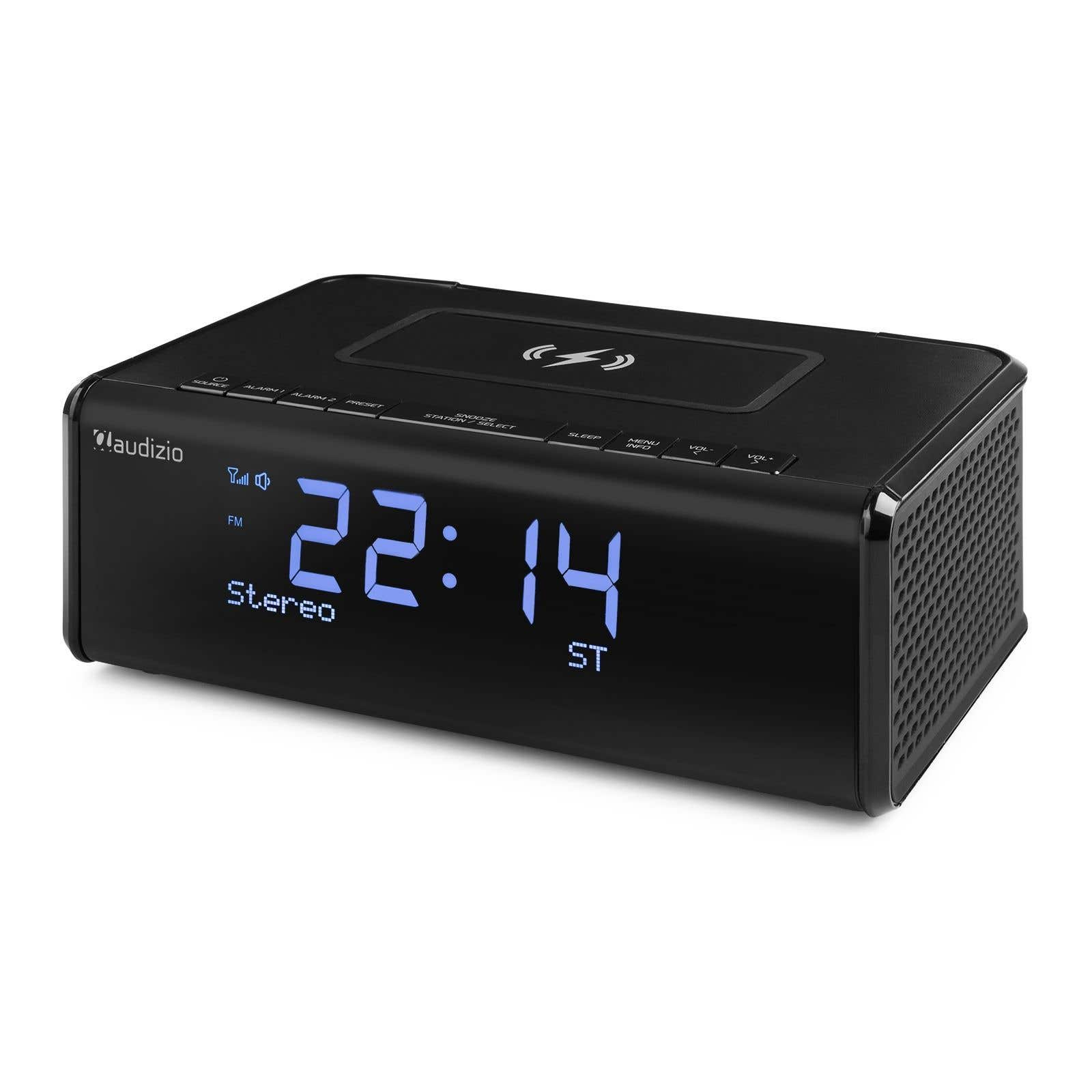 Ein schwarzer digitaler Wecker mit der Anzeige 22:14. Er hat Knöpfe und ein kabelloses Ladepad.