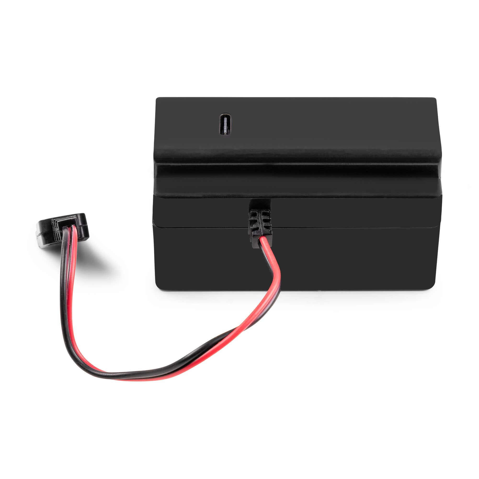 Dispositivo rectangular negro con un cable negro y rojo. Un puerto USB es visible. El fondo es blanco.