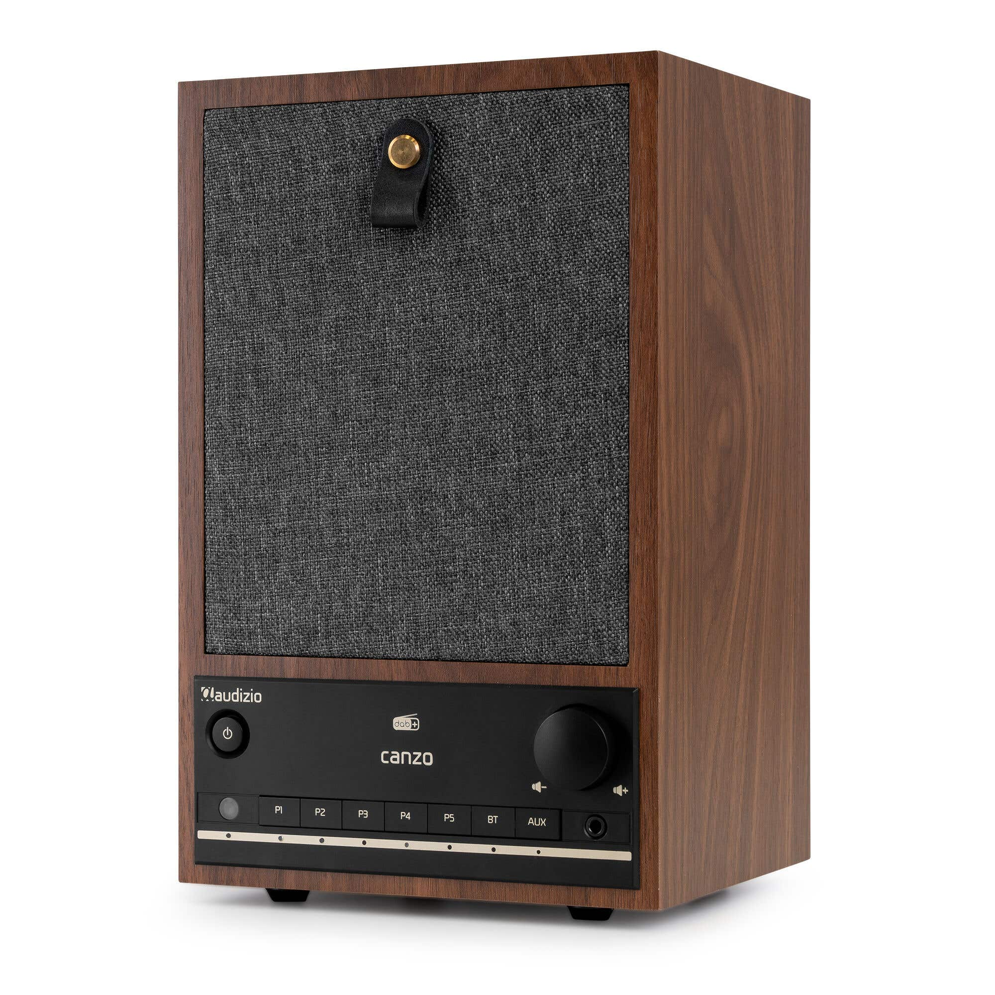 Un altavoz de madera marrón con un panel frontal negro, cubierta de tela y una correa de cuero.