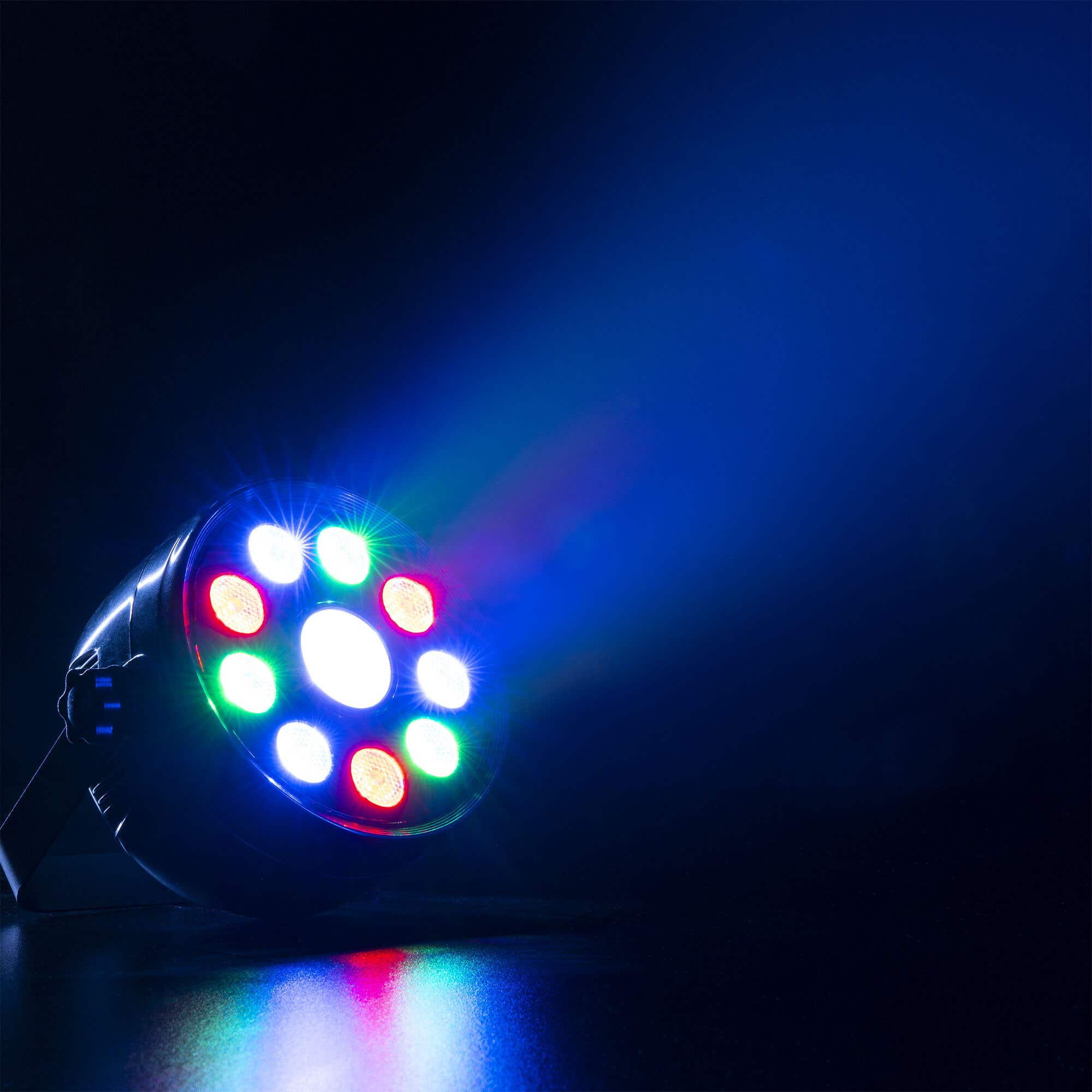 Una luz de escenario con luces rojas, verdes y azules. El fondo es azul oscuro.