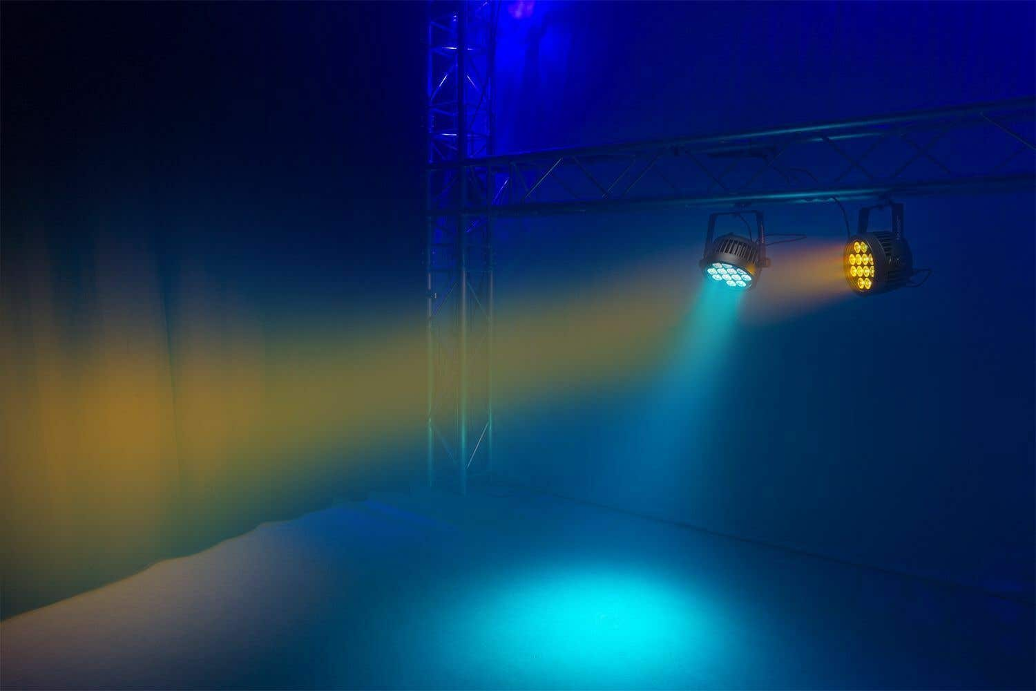 Escenario con dos luces, una azul y otra amarilla, brillando sobre el escenario. Estructura metálica a la derecha.