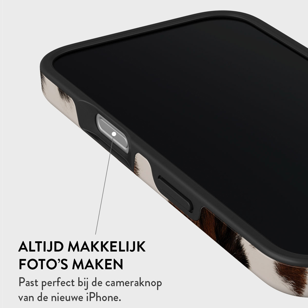 Close-up van een telefoonhoesje met koeienhuidpatroon. De tekst luidt: Altijd makkelijk foto's maken. Perfecte pasvorm voor de cameraknop van iPhone.