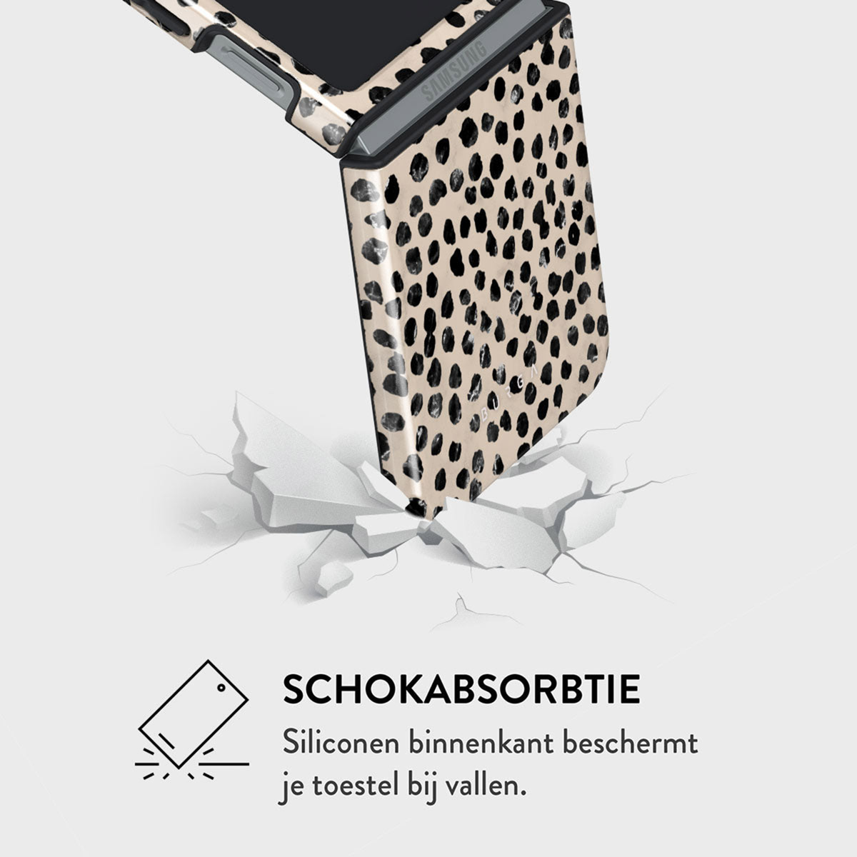 Een telefoonhoesje met zwart-beige dalmatiërpatroon dat een wit oppervlak breekt. De hoes valt, wat impactbescherming aangeeft.