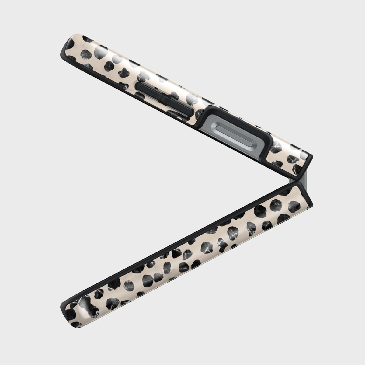 Een open haarglatter met een beige en zwart dalmatiërpatroon op een witte achtergrond. De handgreep is zwart en grijs.