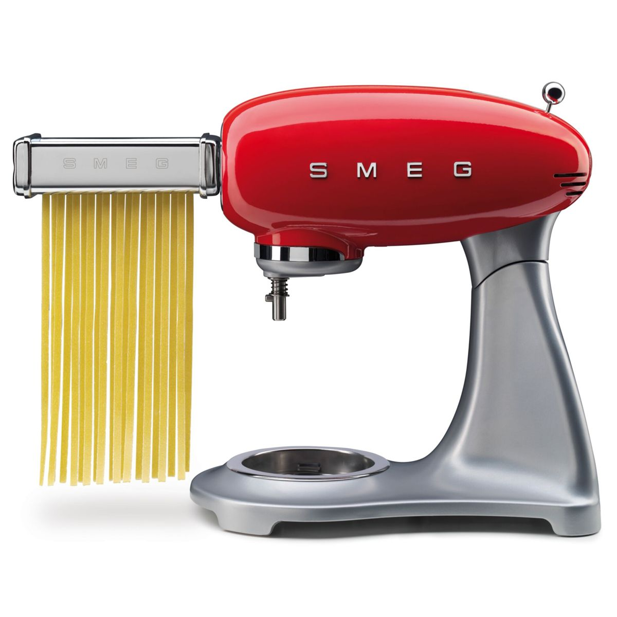 Máquina de pasta Smeg roja con base plateada. Fideos frescos salen de la máquina de pasta.