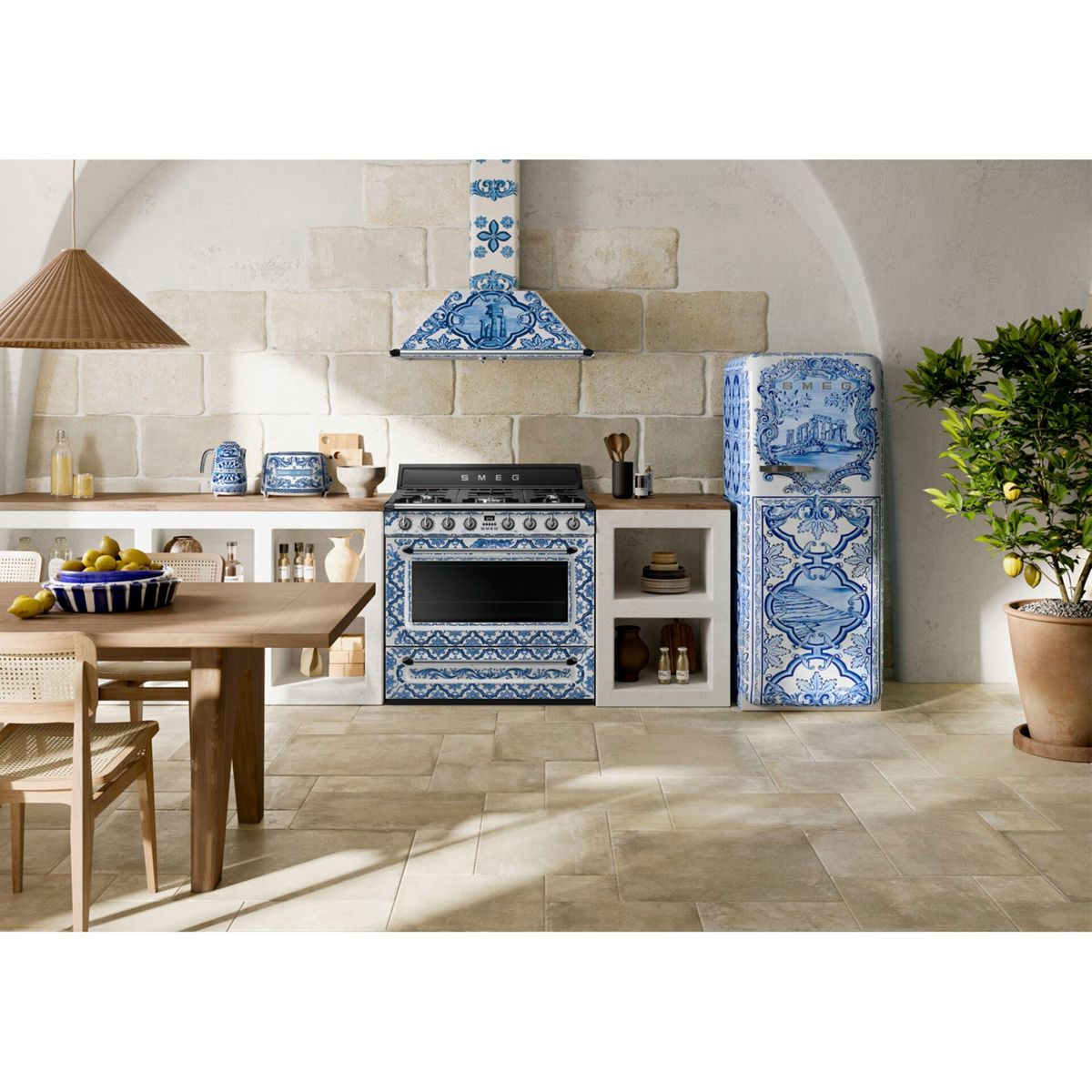 Kuchnia z niebiesko-białymi kafelkowanymi urządzeniami, drewnianym stołem i drzewkiem cytrynowym w doniczce.