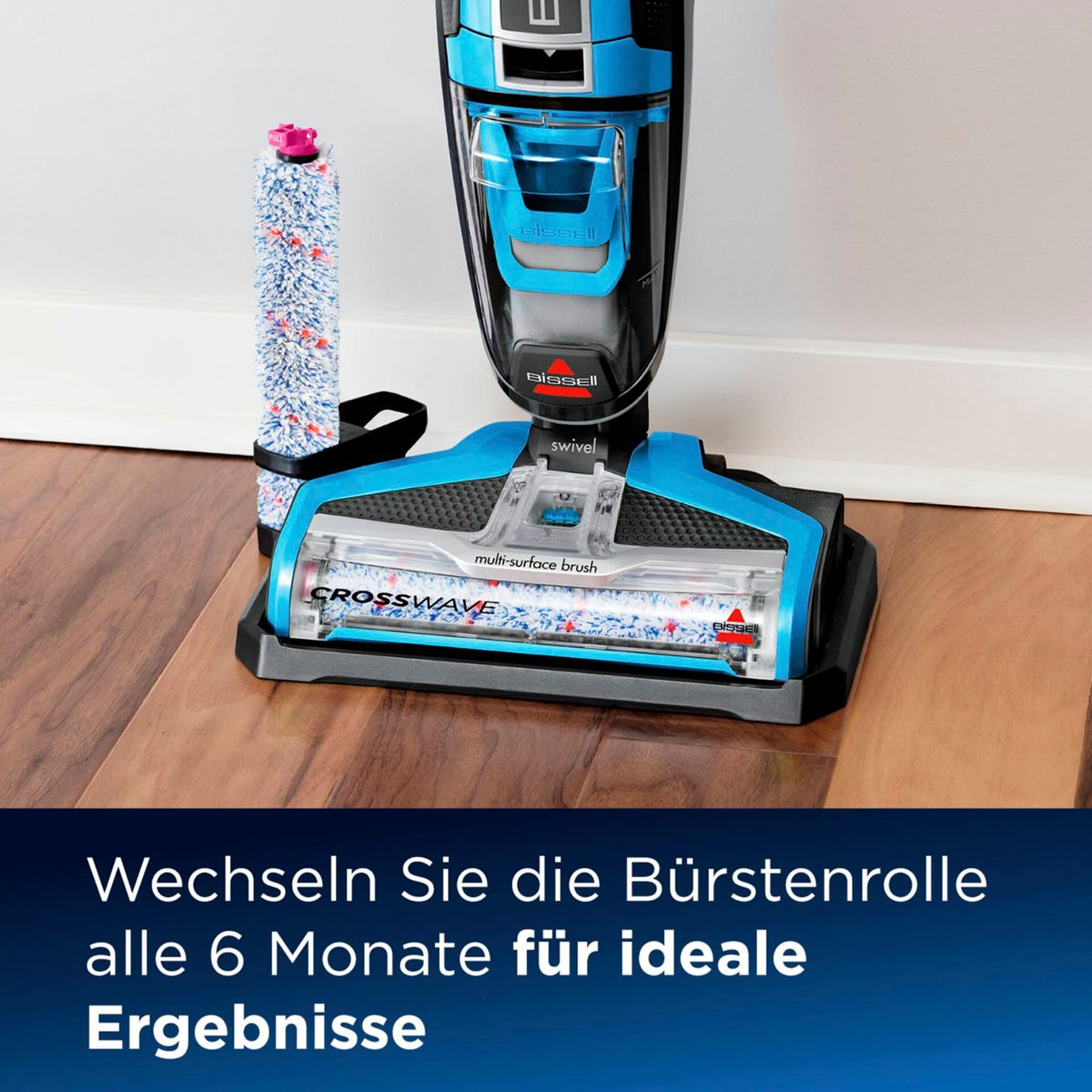 Ein blau-schwarzer Bissell Crosswave Staubsauger mit einer zusätzlichen Rolle steht auf einem Holzboden. Text: Bürstenrolle alle 6 Monate wechseln.