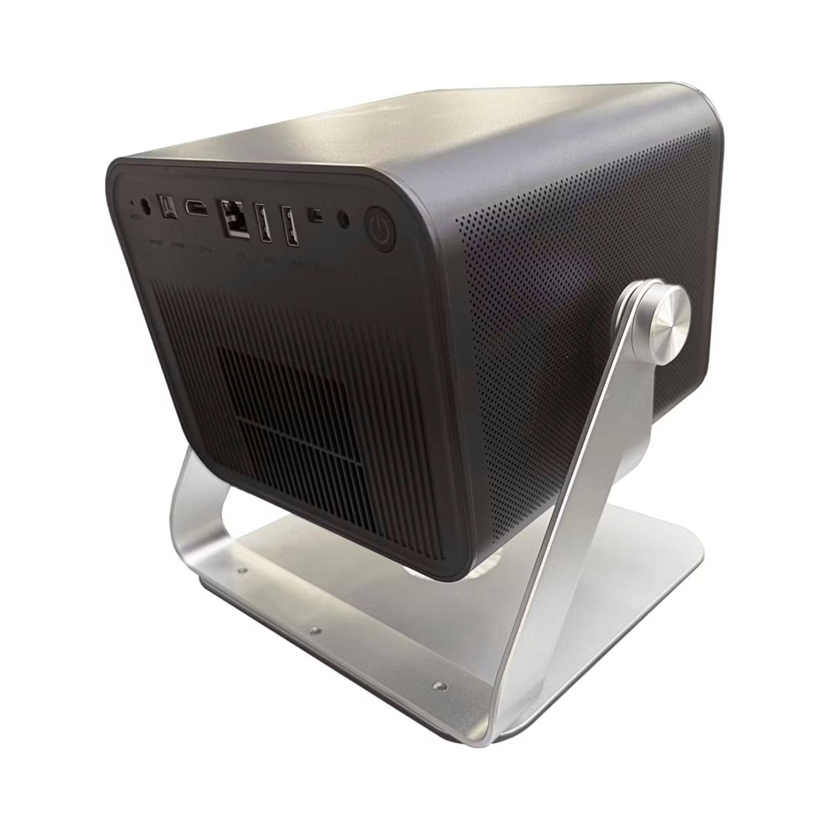 Czarny komputer na srebrnej podstawce. Komputer ma porty i przycisk zasilania. Podstawka jest łukowata i prostokątna.