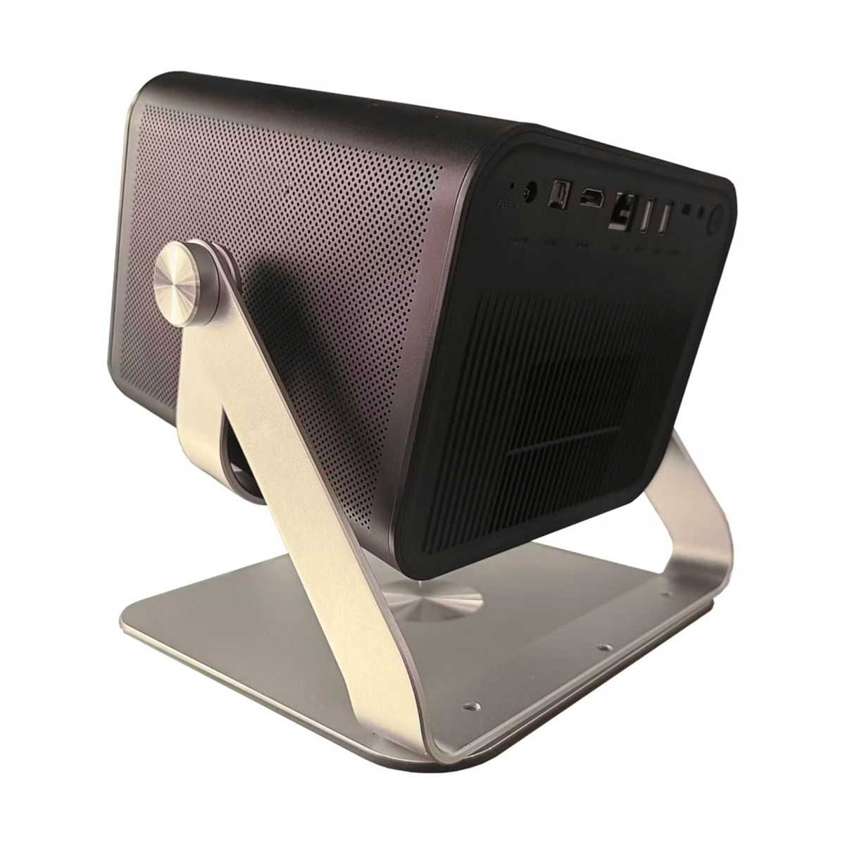 Czarny projektor stoi na srebrnym stojaku. Ma perforowany bok i widoczne porty. Stojak jest solidny i nowoczesny.