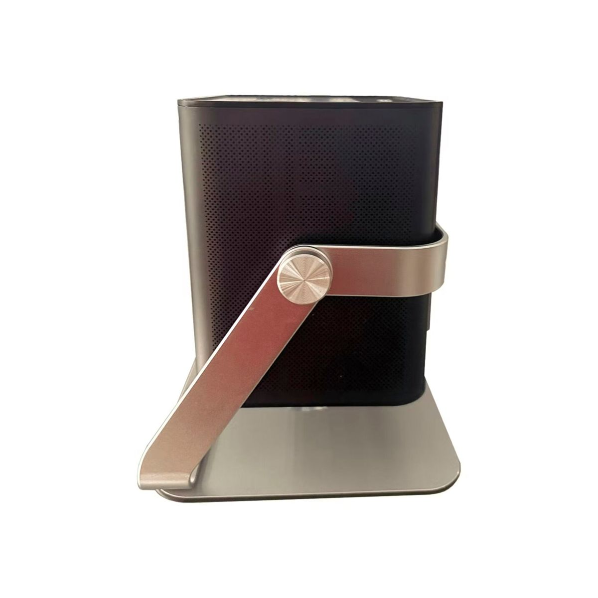 Czarny głośnik ze srebrnym stojakiem. Głośnik ma perforowany przód. Stojak ma okrągły element dekoracyjny.