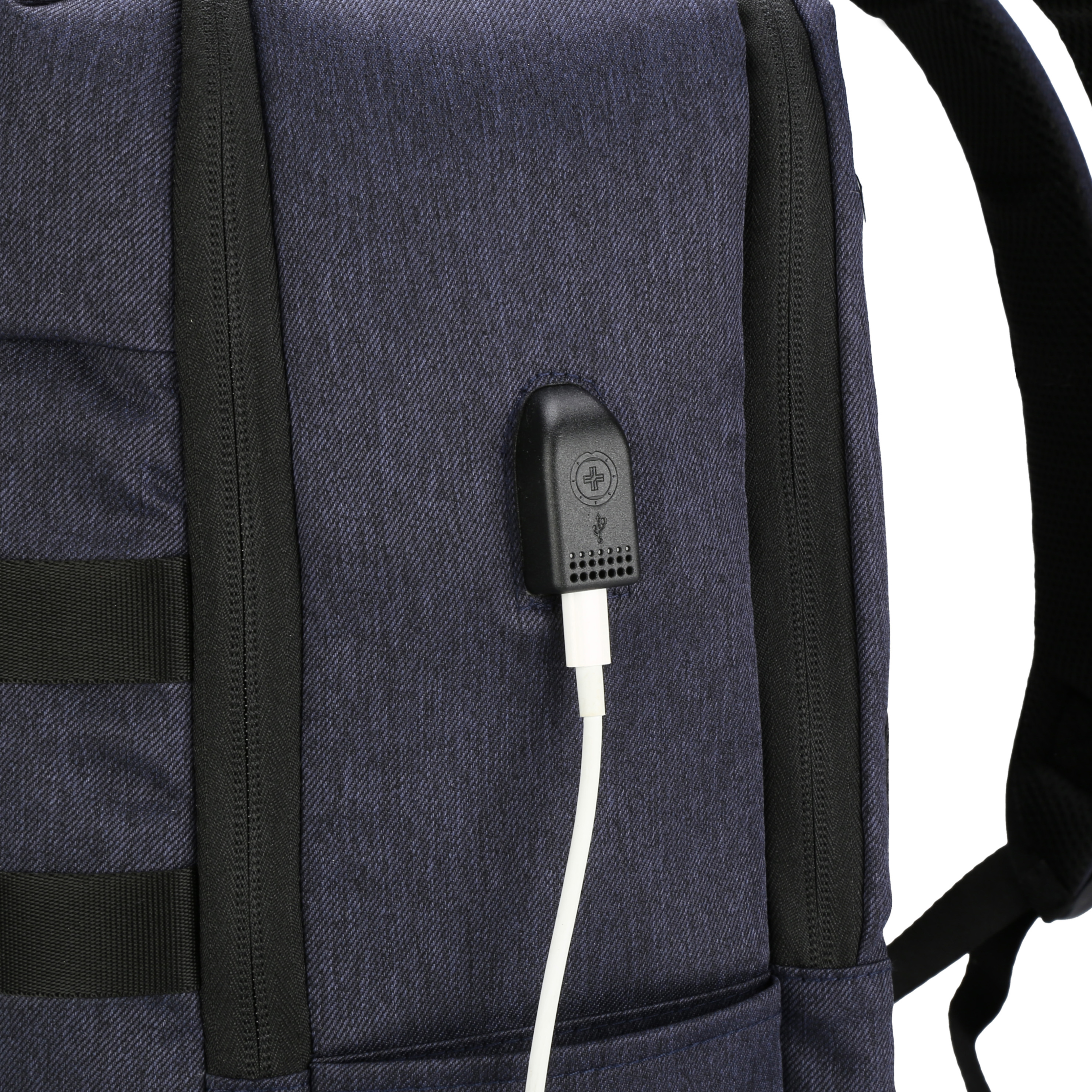 Primo piano di uno zaino blu con un cavo USB bianco collegato a una porta nera, che mostra trame e cinghie.