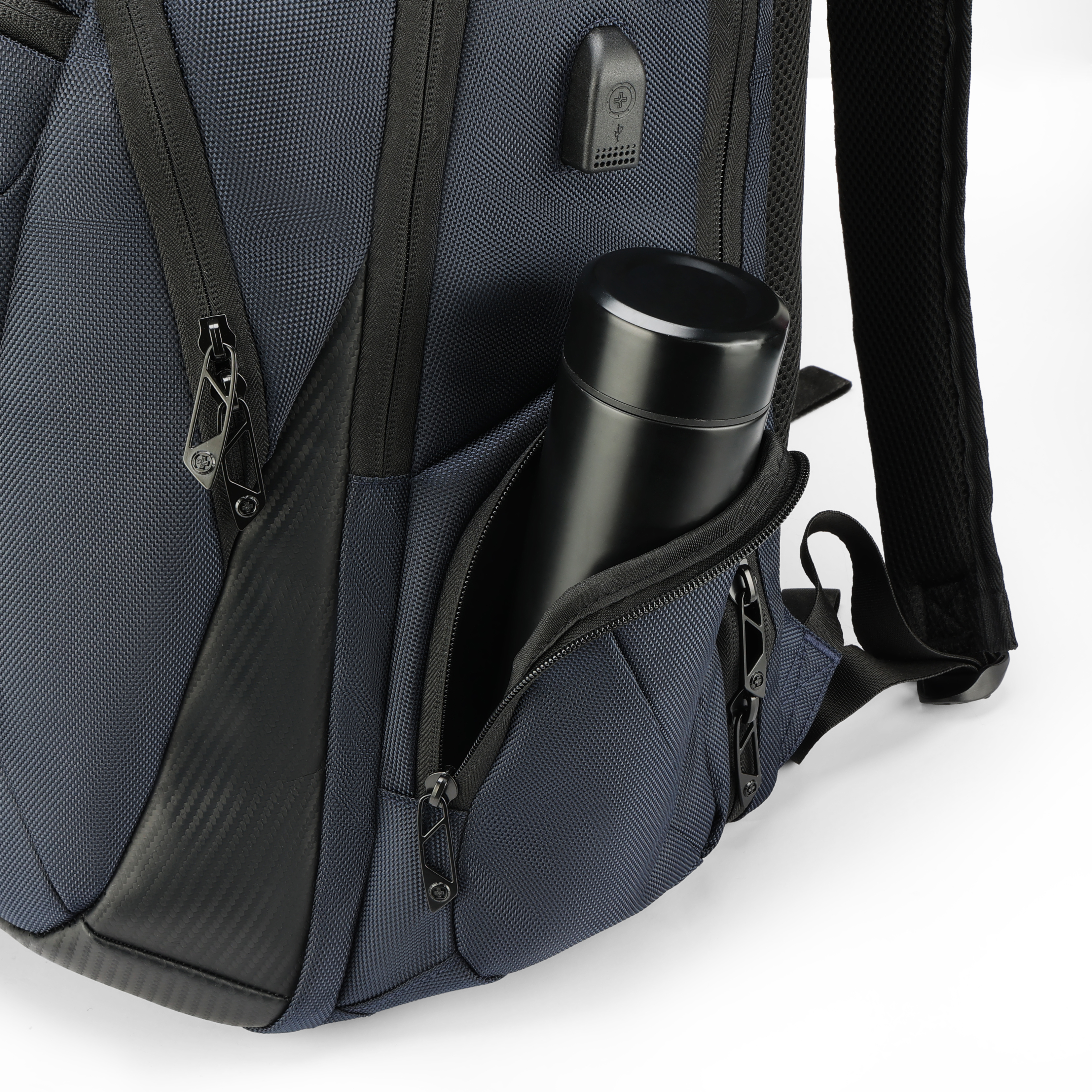Uno zaino blu navy con una borraccia nera in una tasca laterale. Sono visibili cerniere e dettagli neri.