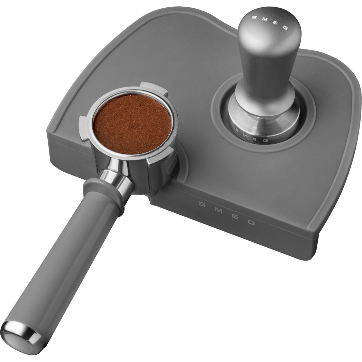 Graues SMEG-Espressomaschinenzubehör auf grauem Untergrund. Es umfasst einen Siebträger mit Kaffeepulver und einen Tamper.