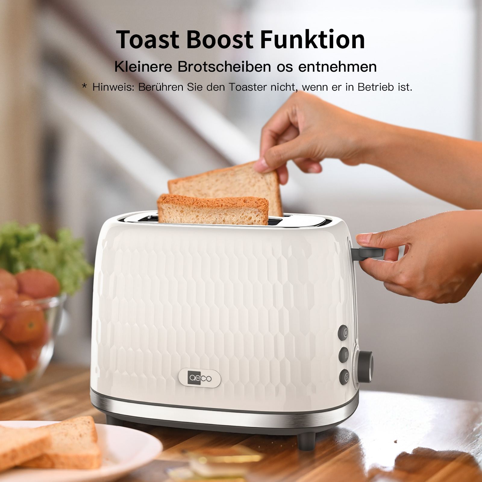 Eine Person nimmt Toast aus einem weißen Toaster. Im Hintergrund befinden sich ein Teller mit Toast und einige Tomaten.