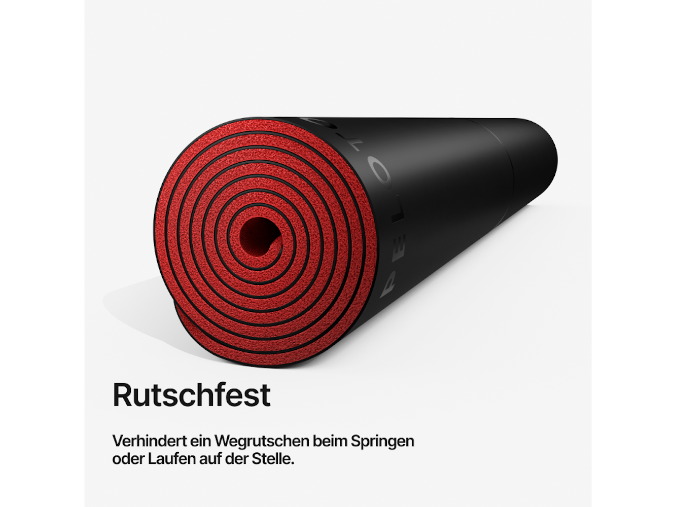 Gerollte schwarze Yogamatte mit roter Innenseite. Text: 'Rutschfest'. Verhindert das Verrutschen beim Springen oder Laufen.