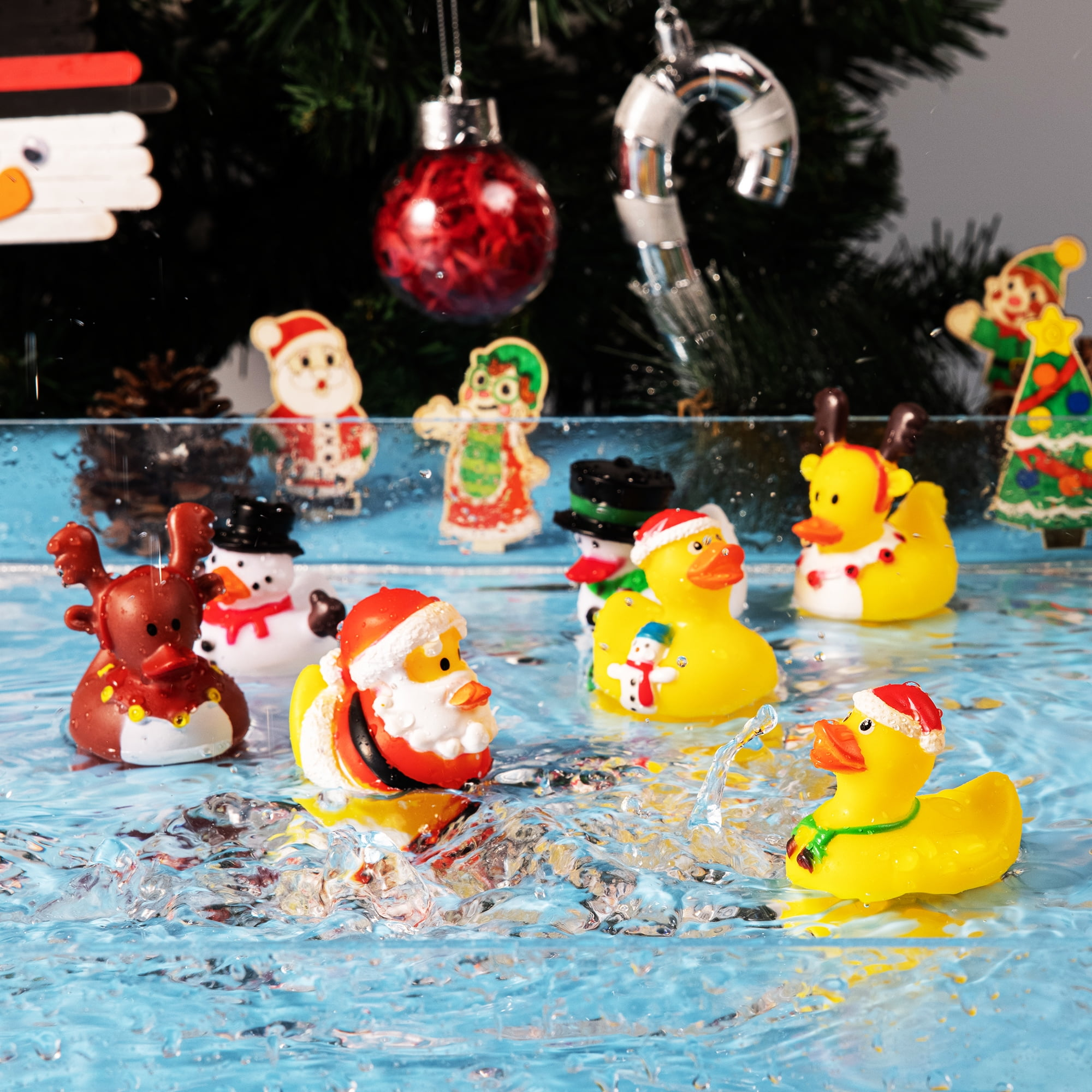 Weihnachtsgummienten im Wasser. Weihnachtsmann, Rentier und Schneemann Enten mit Weihnachtsbaum Hintergrund.
