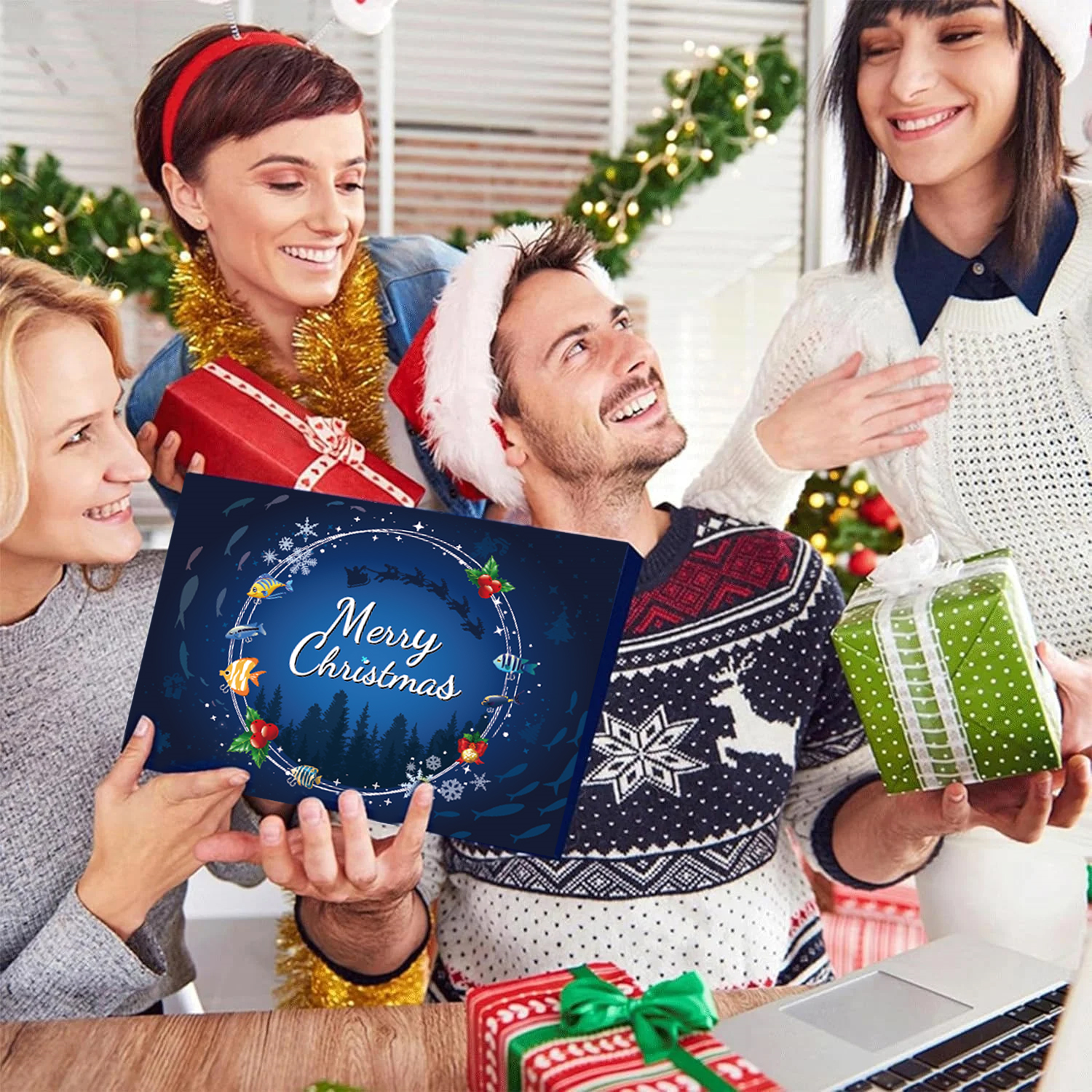 Eine Gruppe von lächelnden Menschen hält Geschenke und eine 'Frohe Weihnachten'-Karte. Weihnachtsdekorationen im Hintergrund.